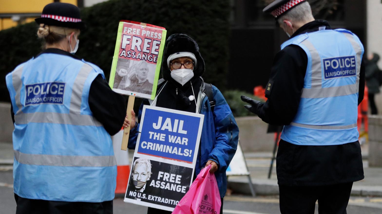 A Julian Assange supporter is spoken to by police officers outside the Old Bailey in London, Monday, Jan. 4, 2021. (Photo: Kirsty Wigglesworth, AP)