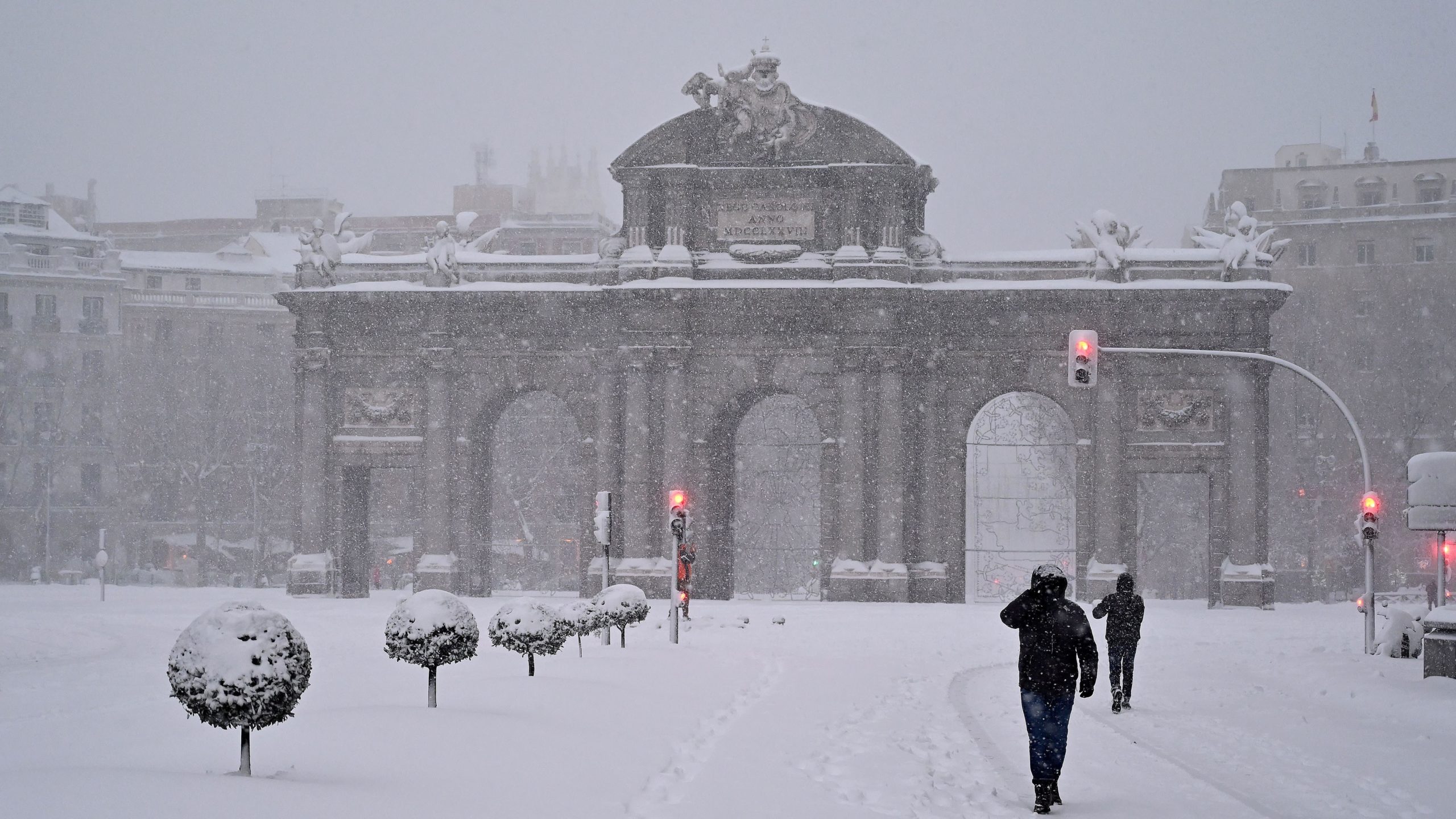 People walk amid a heavy snowfall in Madrid on January 9, 2021. (Photo: Gabriel Bouys/AFP, Getty Images)