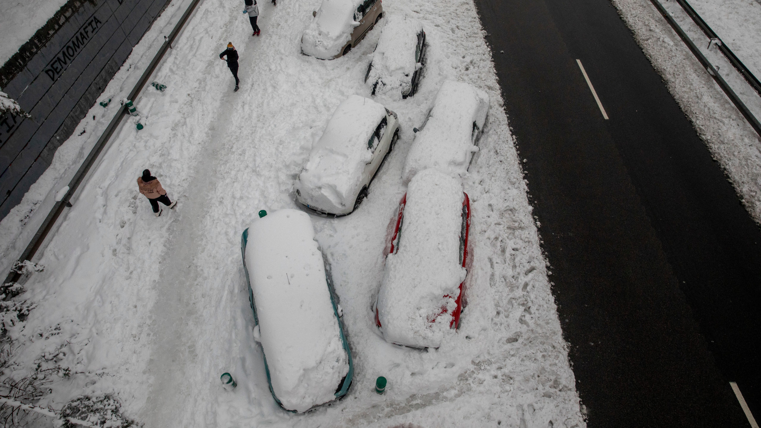Cars are blocked on the snow as people walk past along the M-30 road during heavy snowfall on January 09, 2021 in Madrid, Spain.  (Photo: Pablo Blazquez Dominguez, Getty Images)