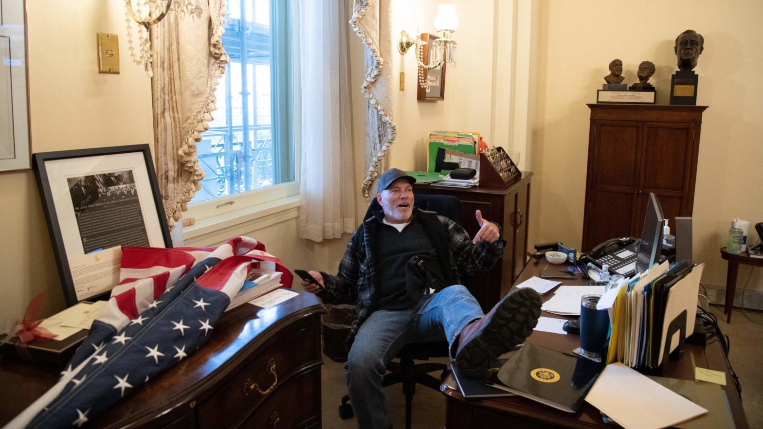 Richard Barnett, a supporter of U.S. President Donald Trump sits inside the office of US Speaker of the House Nancy Pelosi after breaking into the Capitol building with other violent insurgents on January 6, 2021. (Photo: Saul Loeb, Getty Images)