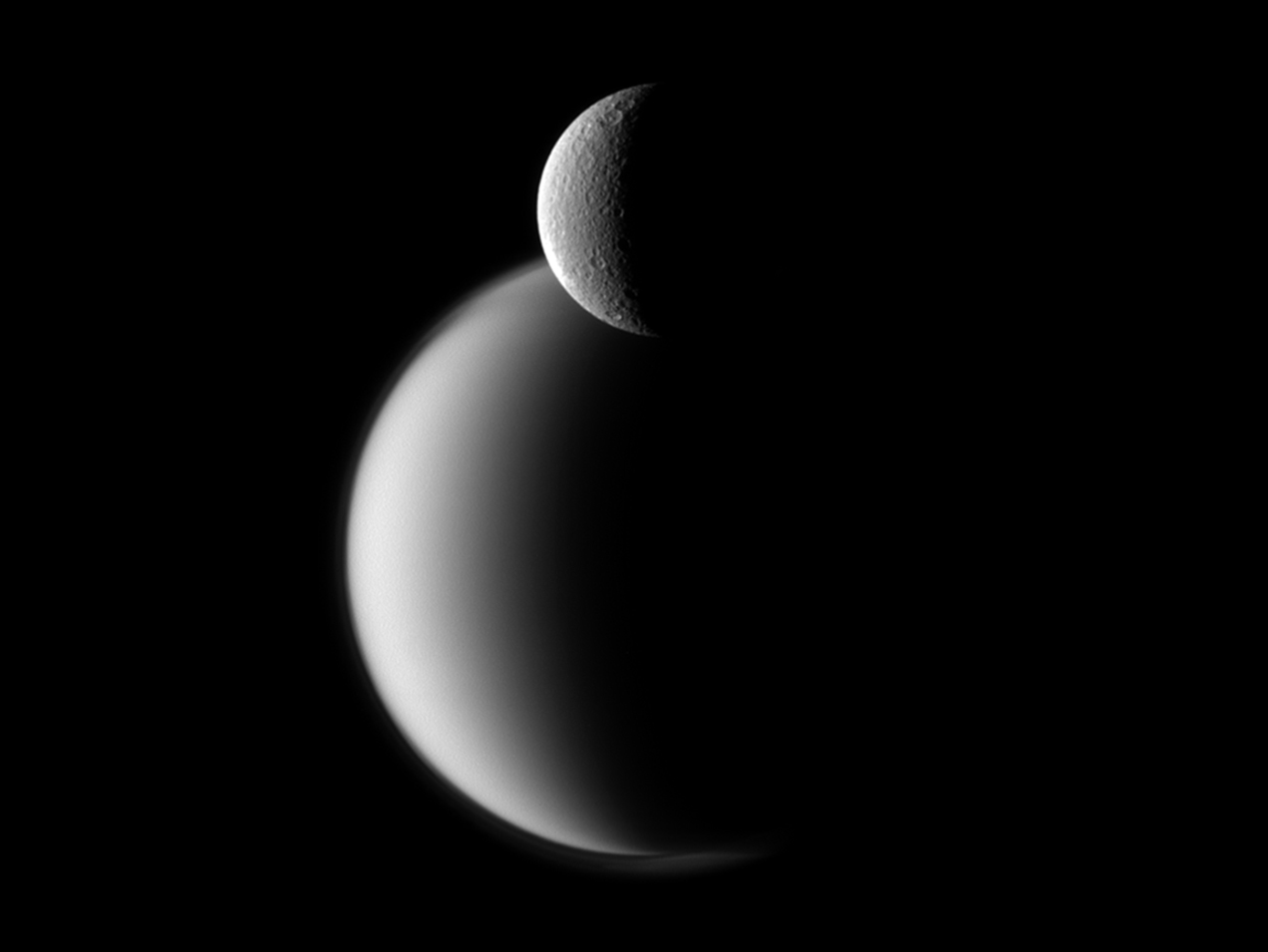 Rhea (front) and the much larger Titan (back). (Image: NASA/JPL-Caltech/Space Science Institute, Fair Use)