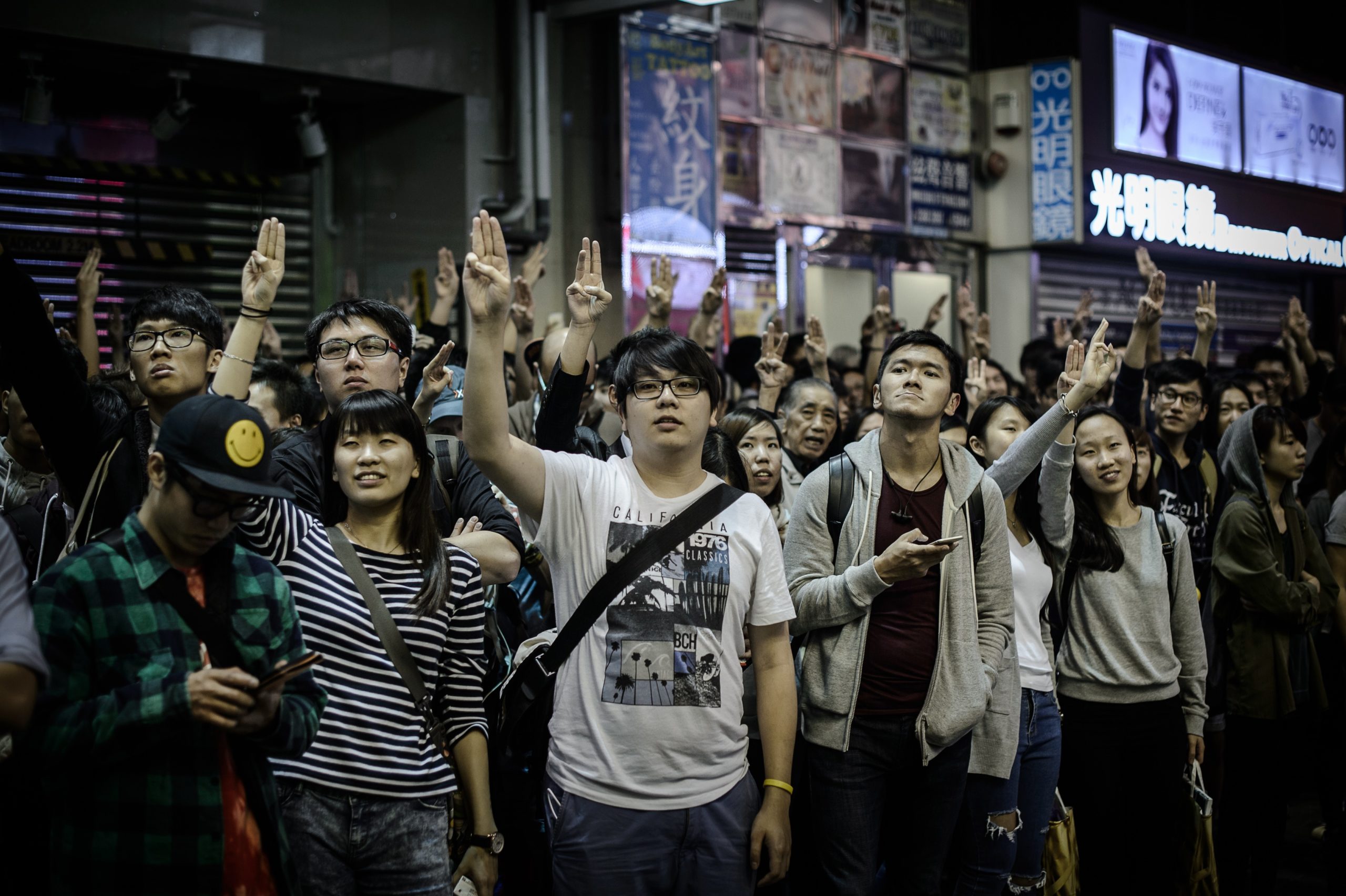 Supporters of the pro-democracy movement flash the three-finger salute from the The Hunger Games as a trailer of the movie is shown on the exterior screen of a theatre in the Mongkok district of Hong Kong on November 28, 2014. (Photo: Philippe Lopez, Getty Images)