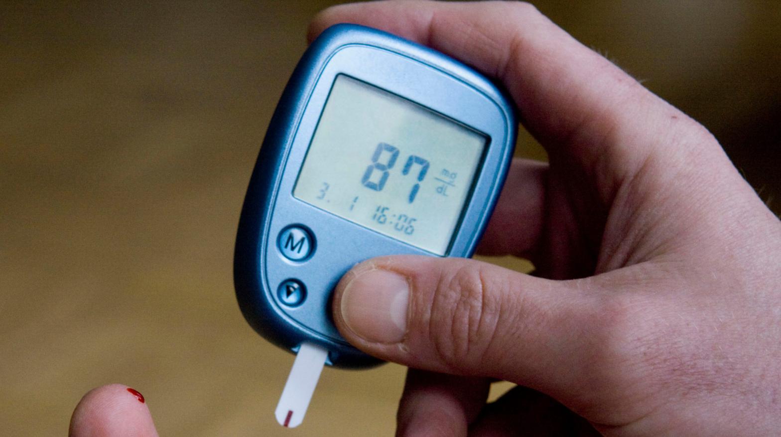 A person measuring their blood sugar level through a finger prick test.  (Photo: Joerg Sarbach, AP)