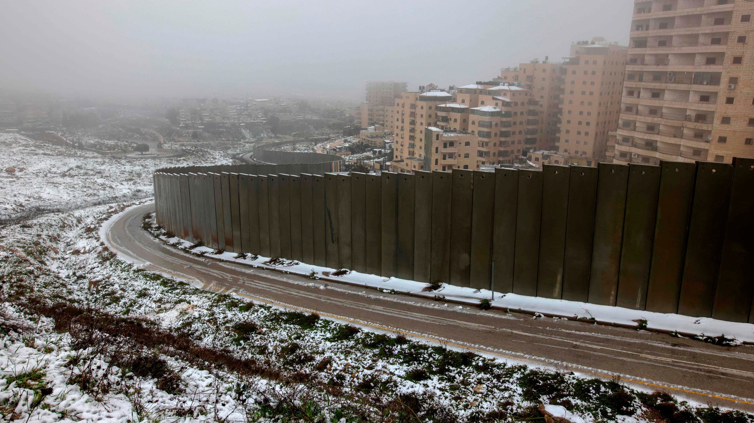 A partial view shows Israel's controversial separation wall and the Palestinian Shuafat refugee camp following heavy snowfall in the Israeli-annexed eastern sector of Jerusalem, on February 18, 2021.  (Photo: AHMAD GHARABLI, Getty Images)