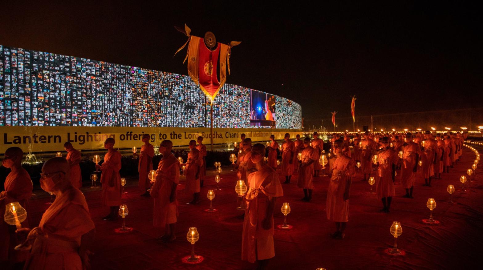 Thai monks walk past a 280-metre-long screen (280.42 m) where virtual devotees take part in an online Makha Bucha Day ceremony on February 26, 2021 in Bangkok, Thailand.  (Photo: Lauren DeCicca, Getty Images)