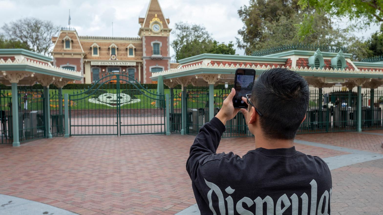 A man takes a photo on the first day of the closure of Disneyland and Disney California Adventure theme parks on March 14, 2020.  (Photo: David McNew/AFP, Getty Images)