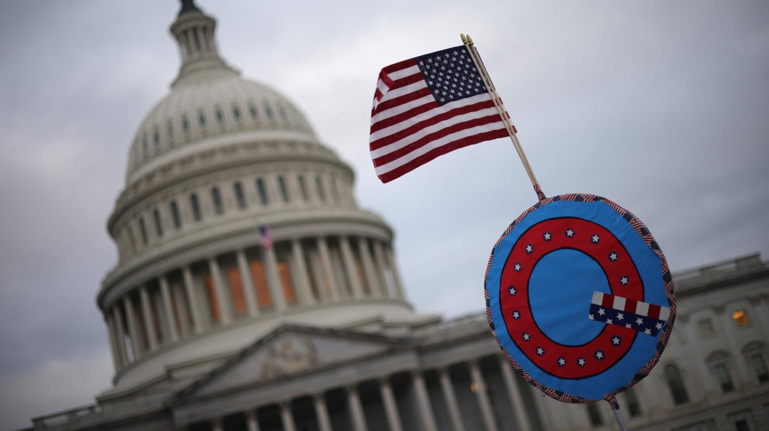 WASHINGTON, DC - JANUARY 06: Supporters of U.S. President Donald Trump fly a U.S. flag with a symbol from the group QAnon as they gather outside the U.S. Capitol January 06, 2021 in Washington, DC.  (Photo: Win McNamee, Getty Images)