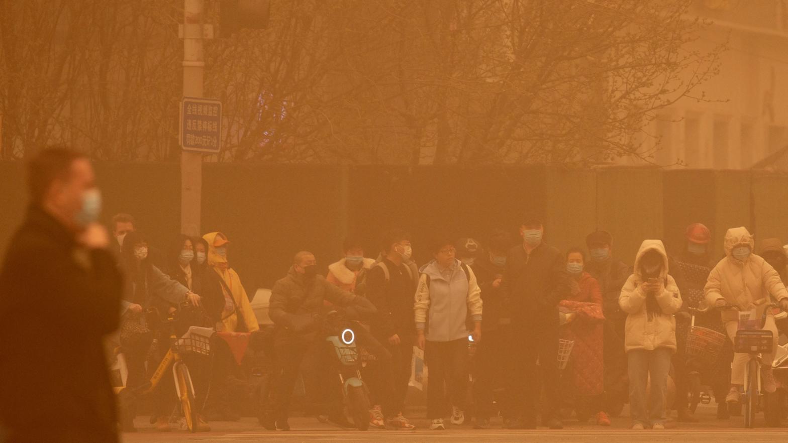 People wait to cross an intersection amid a sandstorm during the morning rush hour in Beijing, Monday, March 15, 2021. (Photo: Mark Schiefelbein, AP)