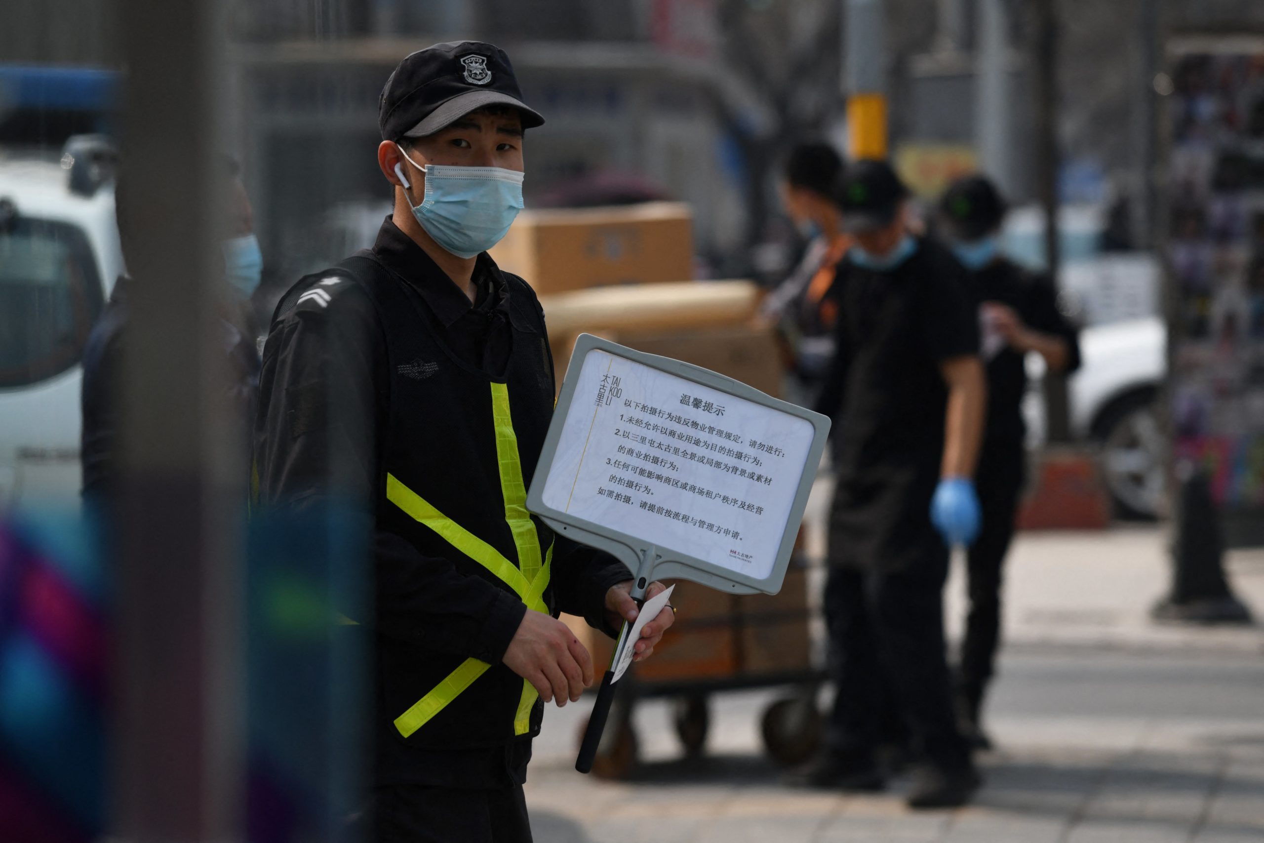 A security guard holds a sign advising that photos are forbidden without permission, outside a store of Swedish clothing giant H&M in Beijing on March 25, 2021, (Photo: Greg Baker/AFP, Getty Images)