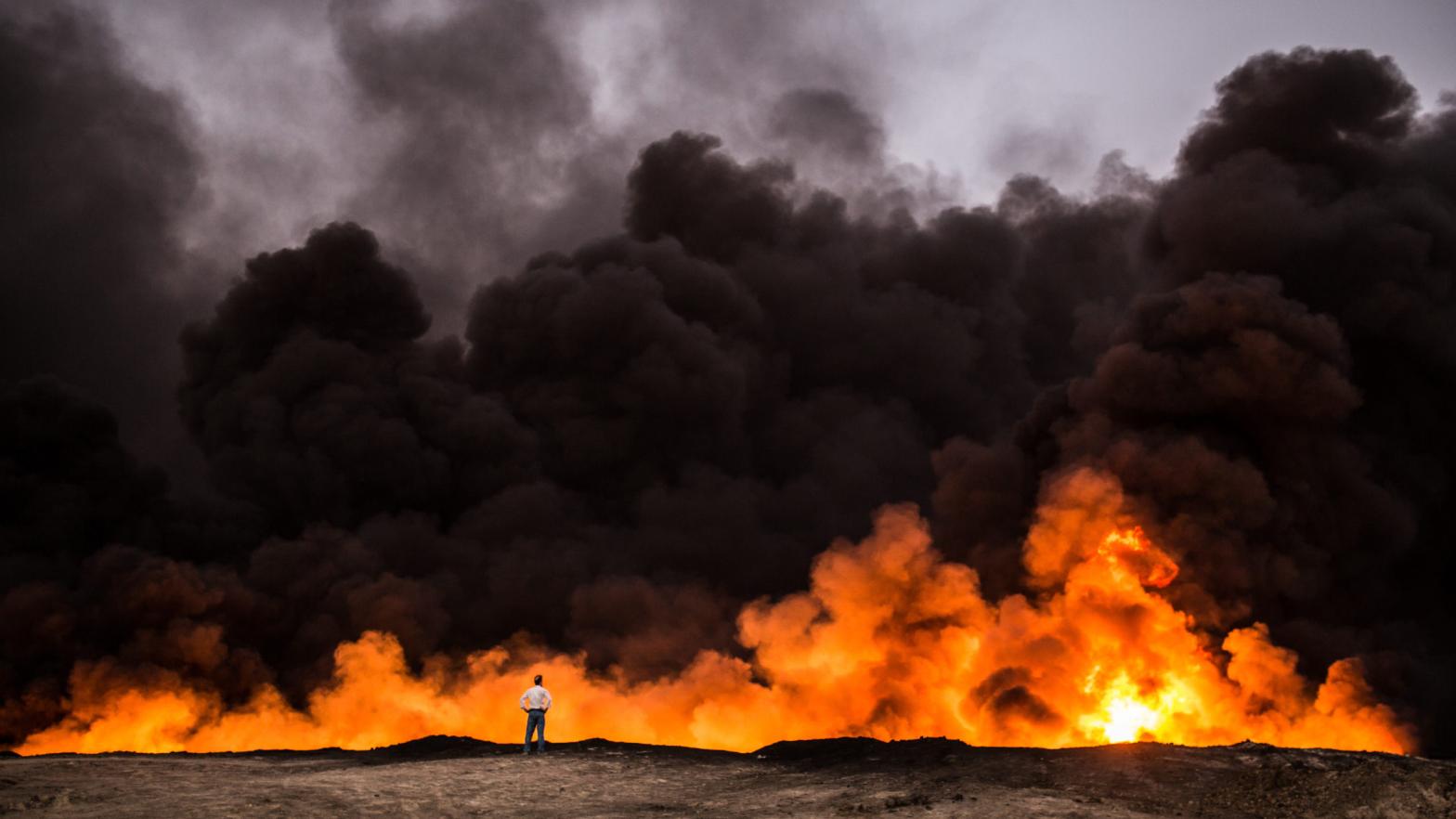 A man stands in front of a fire from oil that has been set ablaze in the Qayyarah area of Iraq. (Photo: Yasin Akgul/AFP, Getty Images)