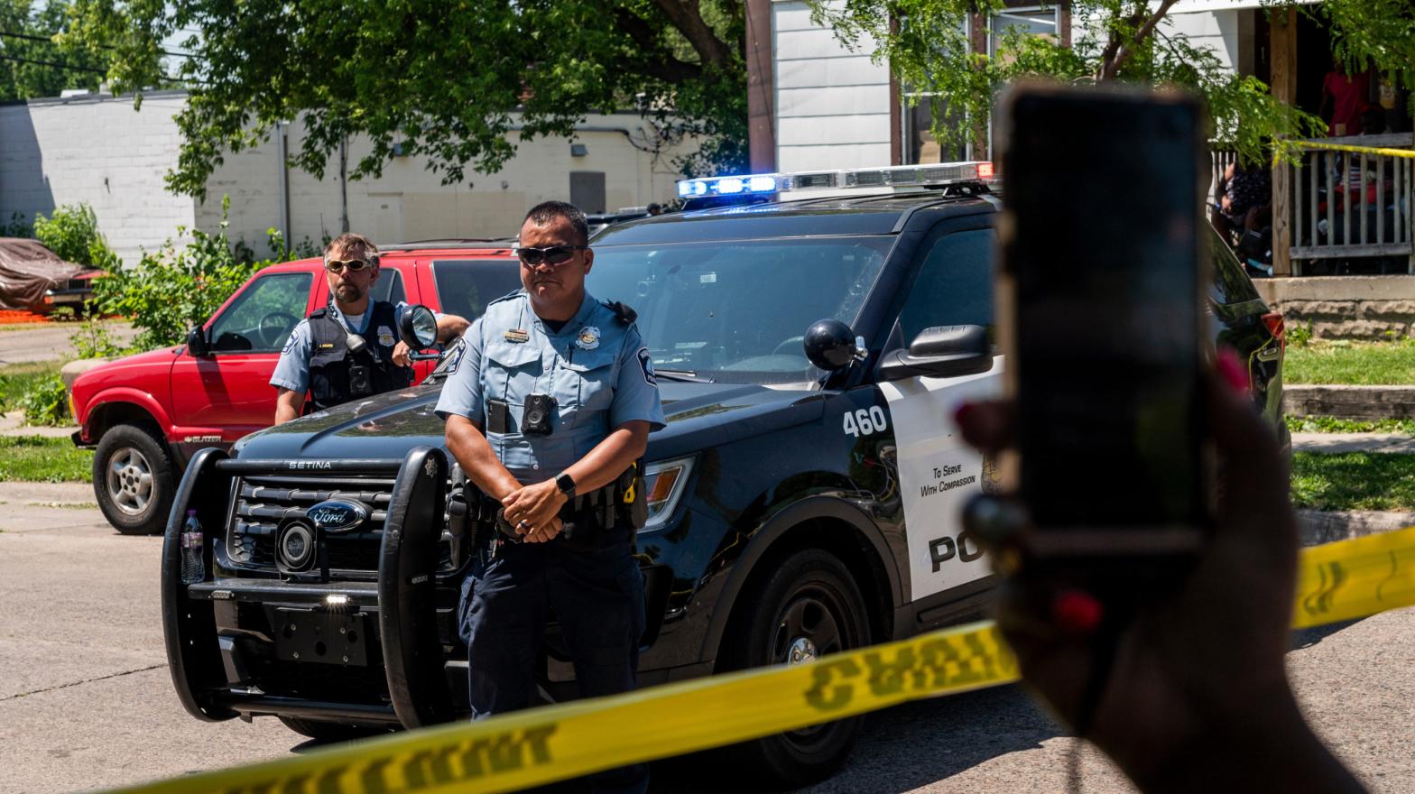 MINNEAPOLIS, MN - JUNE 16: A woman holds up her phone as Minneapolis Police officers respond at a crime scene on June 16, 2020 in Minneapolis, Minnesota. The Minneapolis Police Department has been under increased scrutiny by residents and elected officials after the death of George Floyd in police custody on May 25. (Photo: Stephen Maturen, Getty Images)