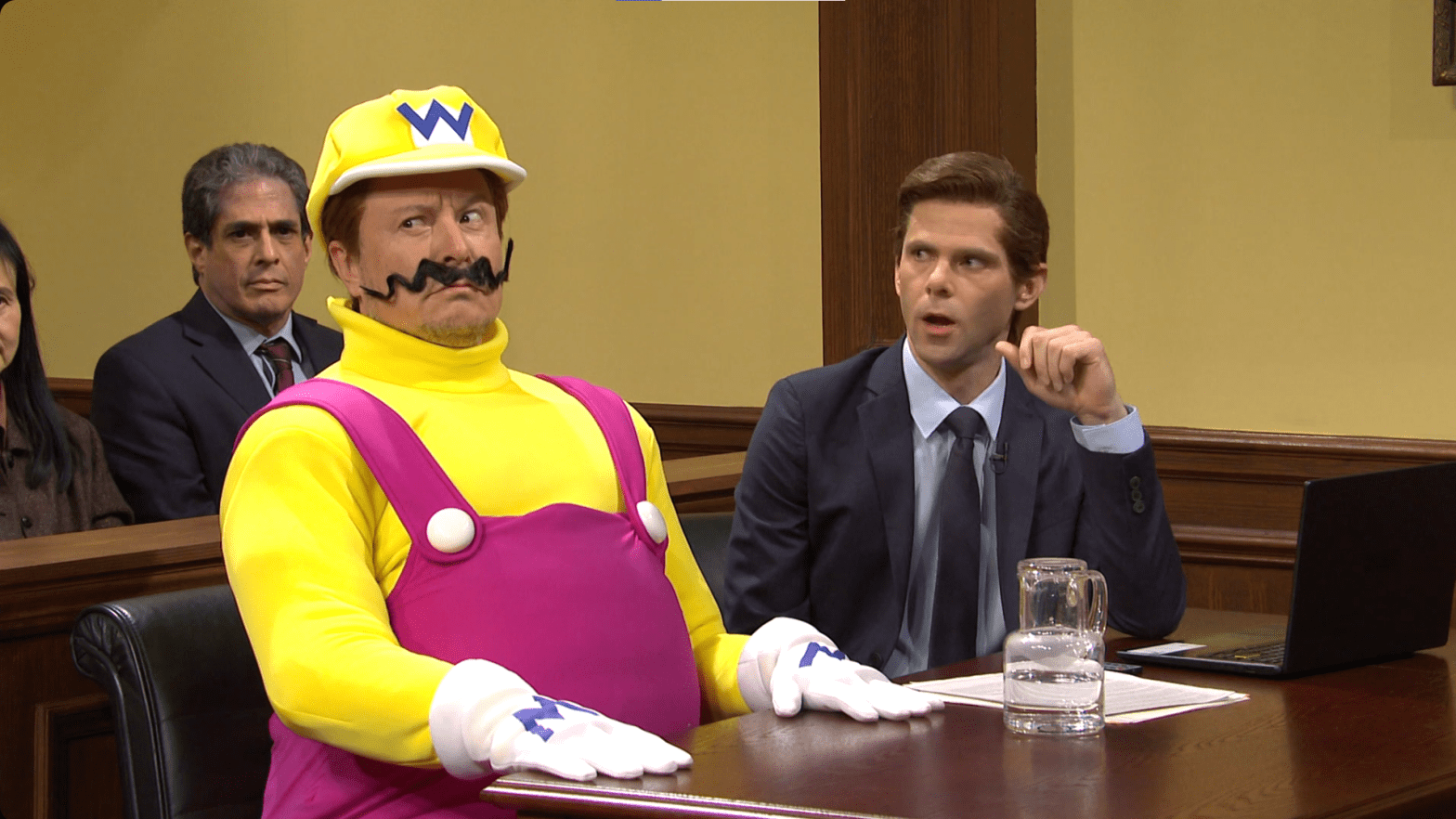 One of the more bizarre sketches from last night's episode of SNL. Tesla CEO Elon Musk, seen here playing Wario, stands trial after being accused of Mario's murder in a banana peel and go-kart related incident.  (Screenshot: Peacock/Gizmodo)