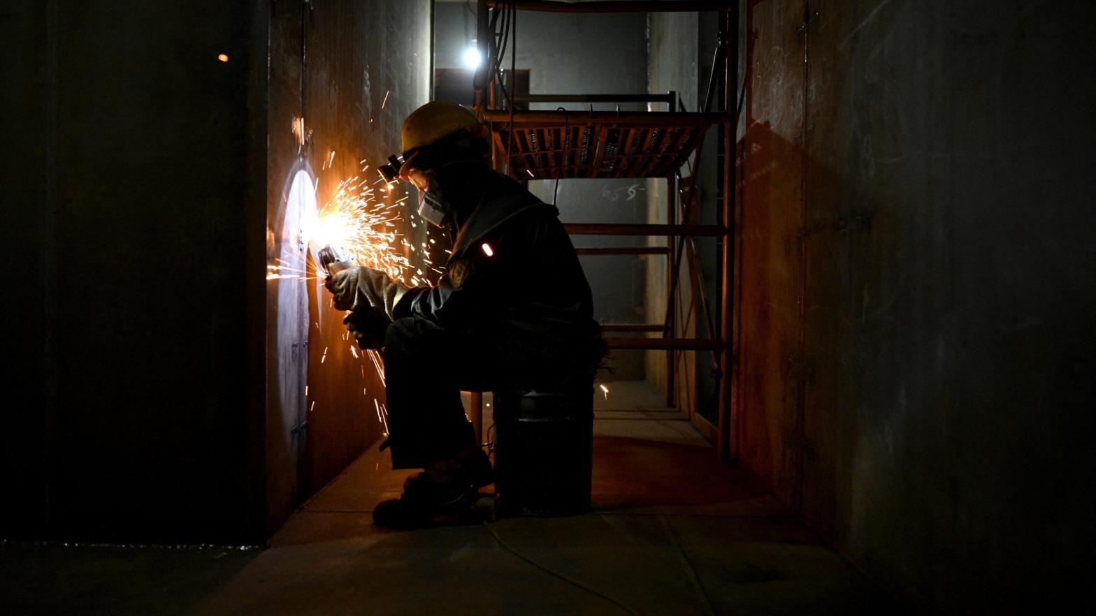 A worker welding metal inside a still-under-construction replica of the Titanic ship in Daying County in China's southwest Sichuan province on April 27, 2021. (Photo: Noel Celis and Qian Ye/AFP, Getty Images)