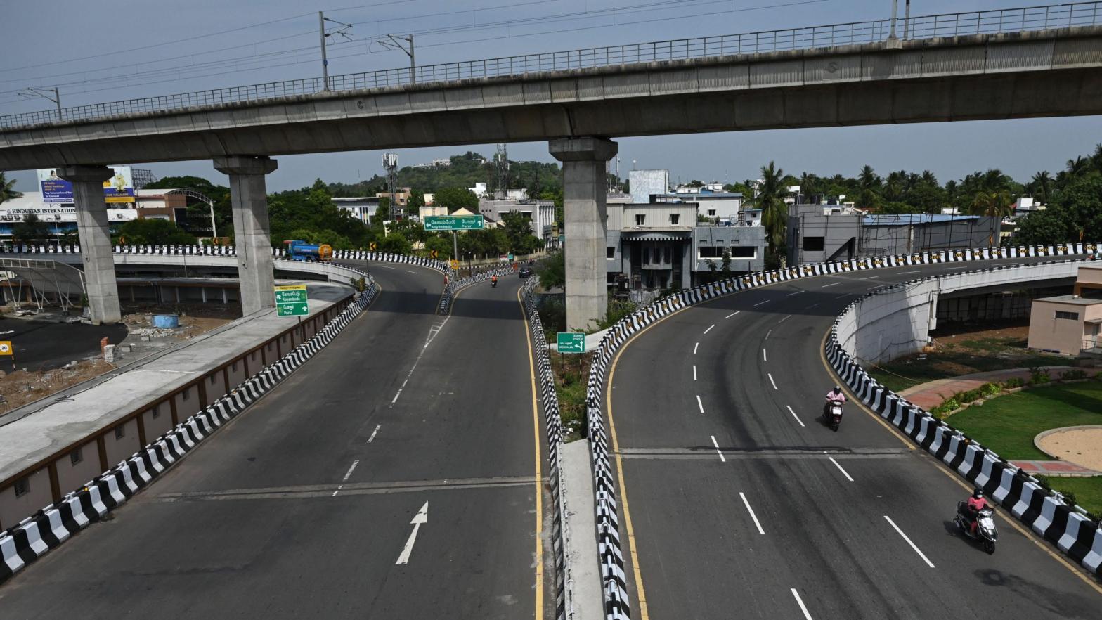 Motorists make their way through a partially deserted road after a complete lockdown was imposed by the state government  in Chennai on May 24, 2021. (Photo: Arun Sankar, Getty Images)