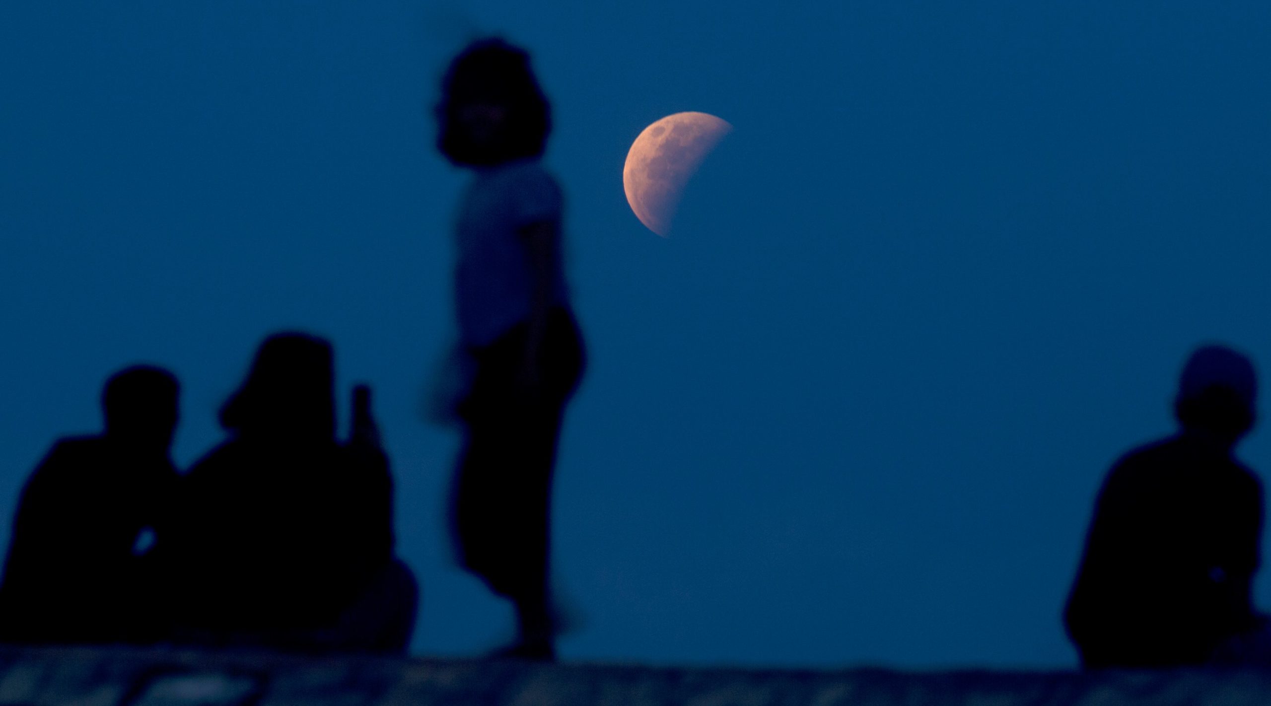 Residents watch the lunar eclipse at Sanur beach in Bali, Indonesia on Wednesday, May 26, 2021.  (Photo: Firdia Lisnawati, AP)