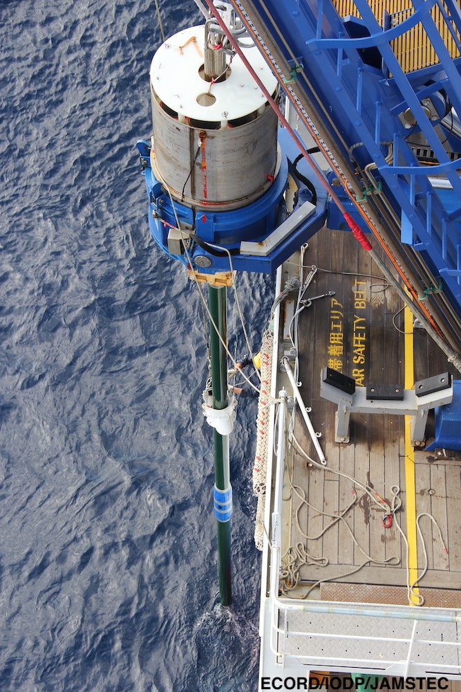 A deck crew member setting a barrel clamp for recovery . (Image: Lena Maeda, ECORD/IODP/JAMSTEC)