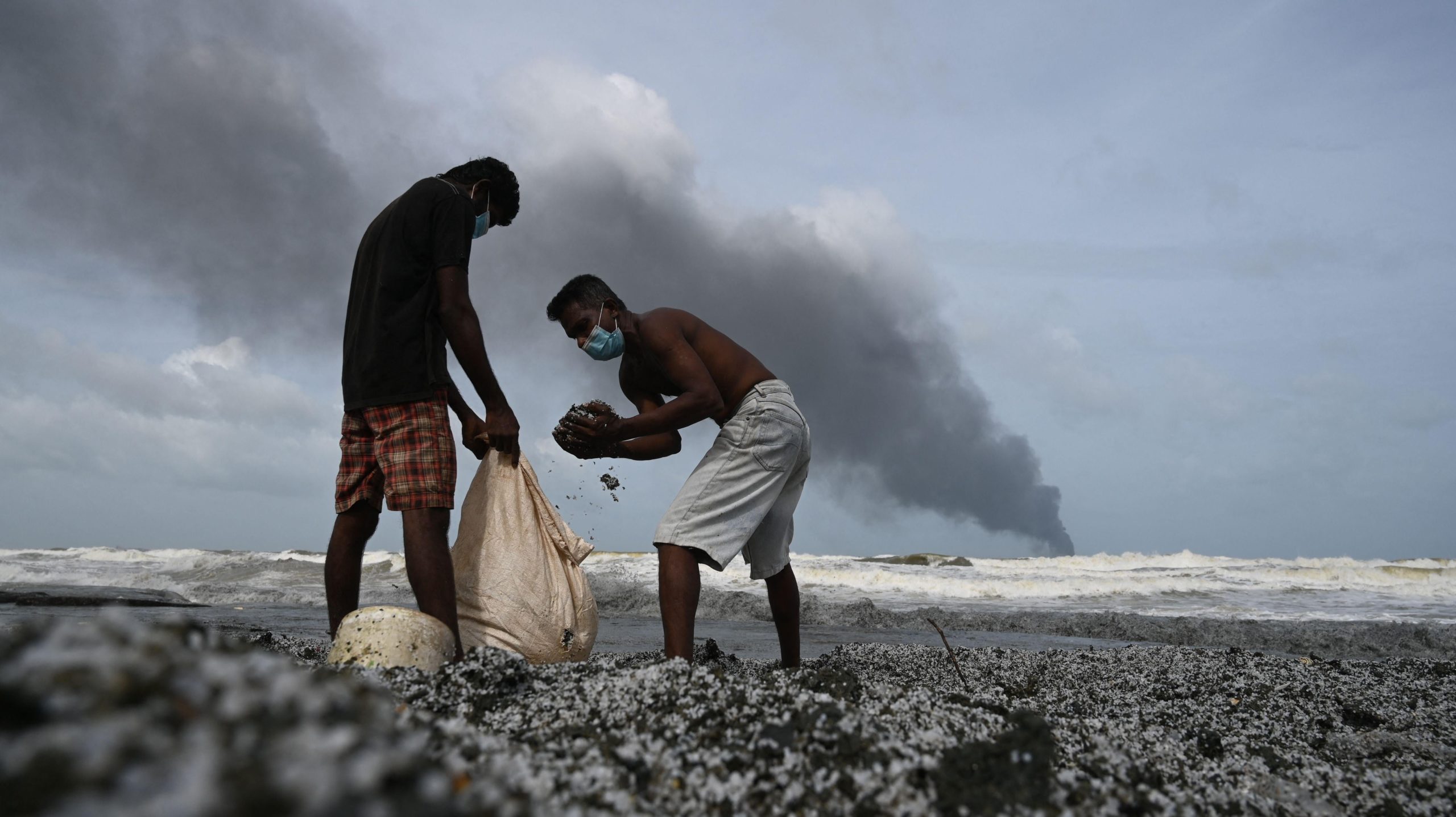 Residents collect debris among plastic pellets spilled by the ship on May 26. (Photo: Lakruwan Wanniarachchi/ AFP, Getty Images)