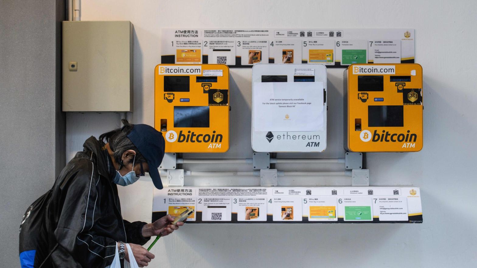 A man walks past cryptocurrency ATMs in Hong Kong in December 2017. (Photo: Anthony Wallace/AFP, Getty Images)