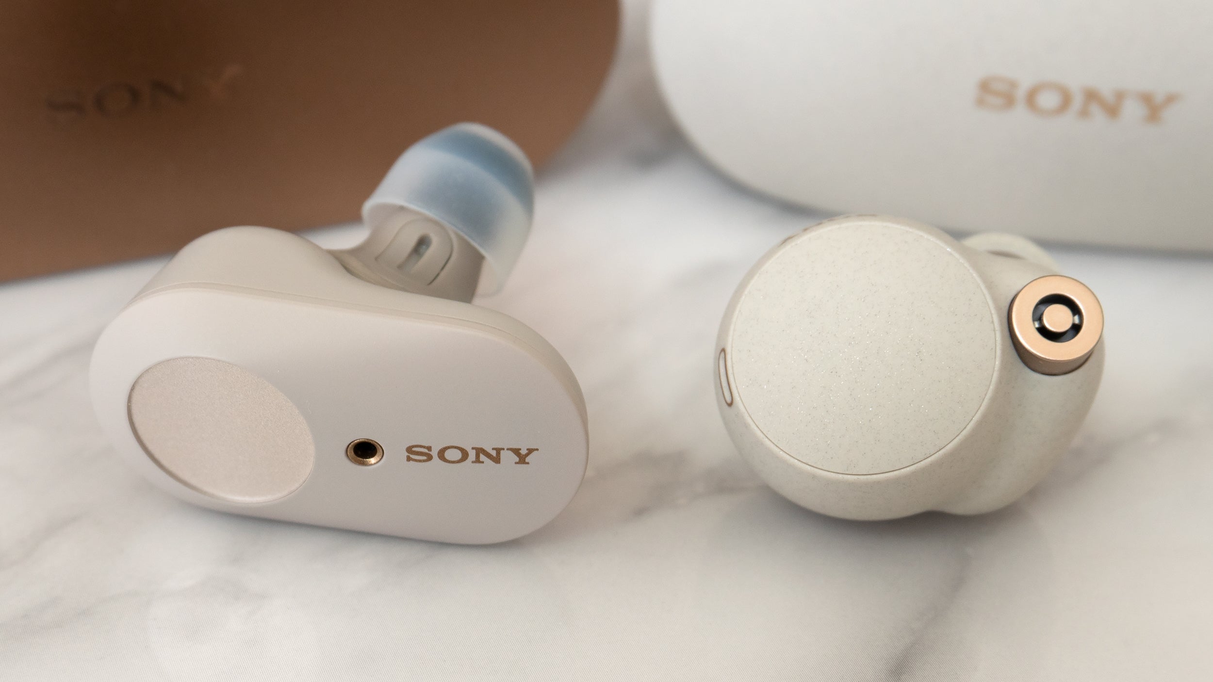 The Sony WF-1000XM4 buds (right) are smaller and lighter than the Sony WF-1000XM3s (left), but they're still quite a bit larger than most of the premium wireless earbud options out there. (Photo: Andrew Liszewski/Gizmodo)