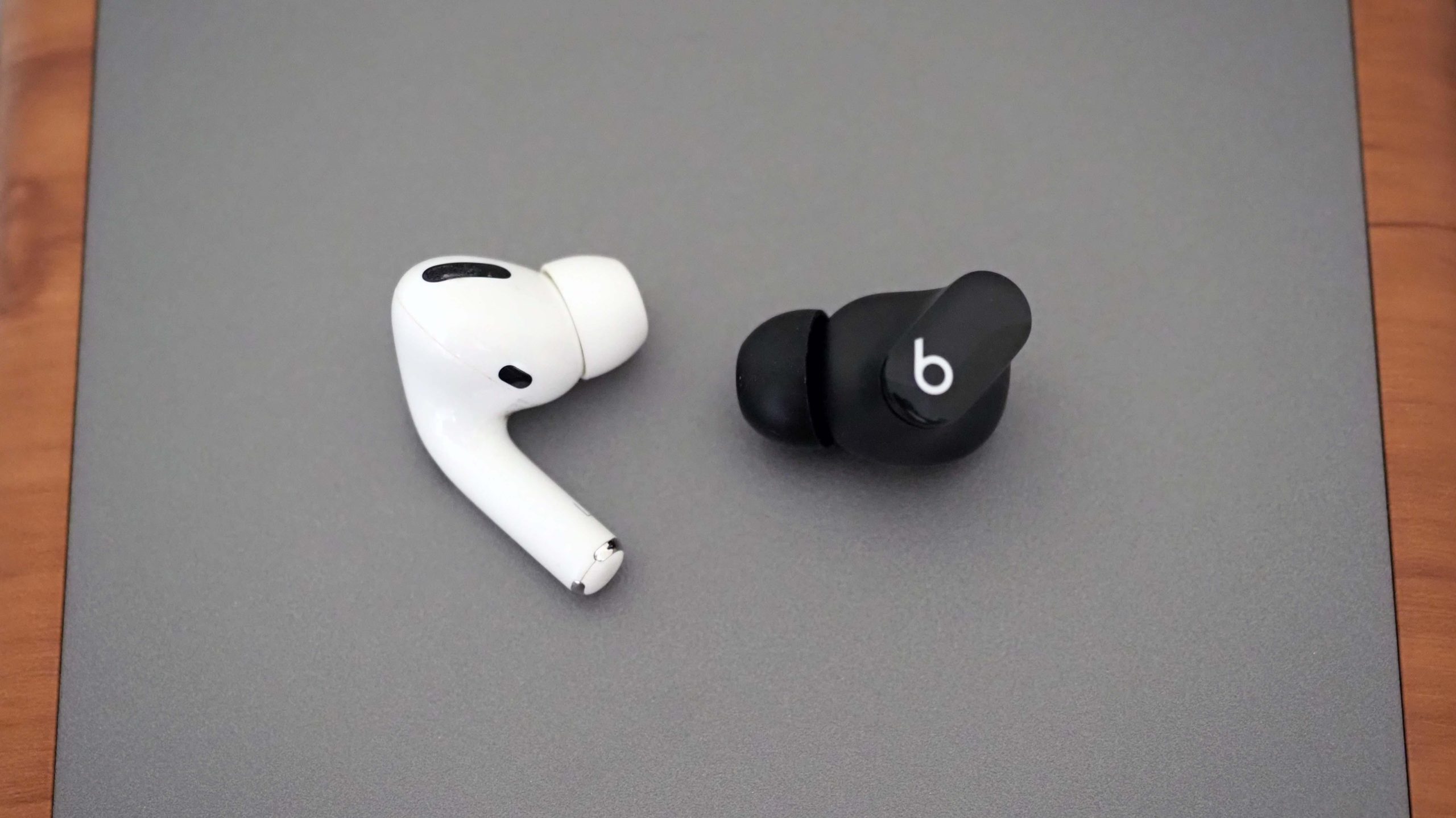 The Beats Studio Buds (right) have a more subtle design and more comfortable fit than AirPods Pro (left). (Photo: Caitlin McGarry/Gizmodo)