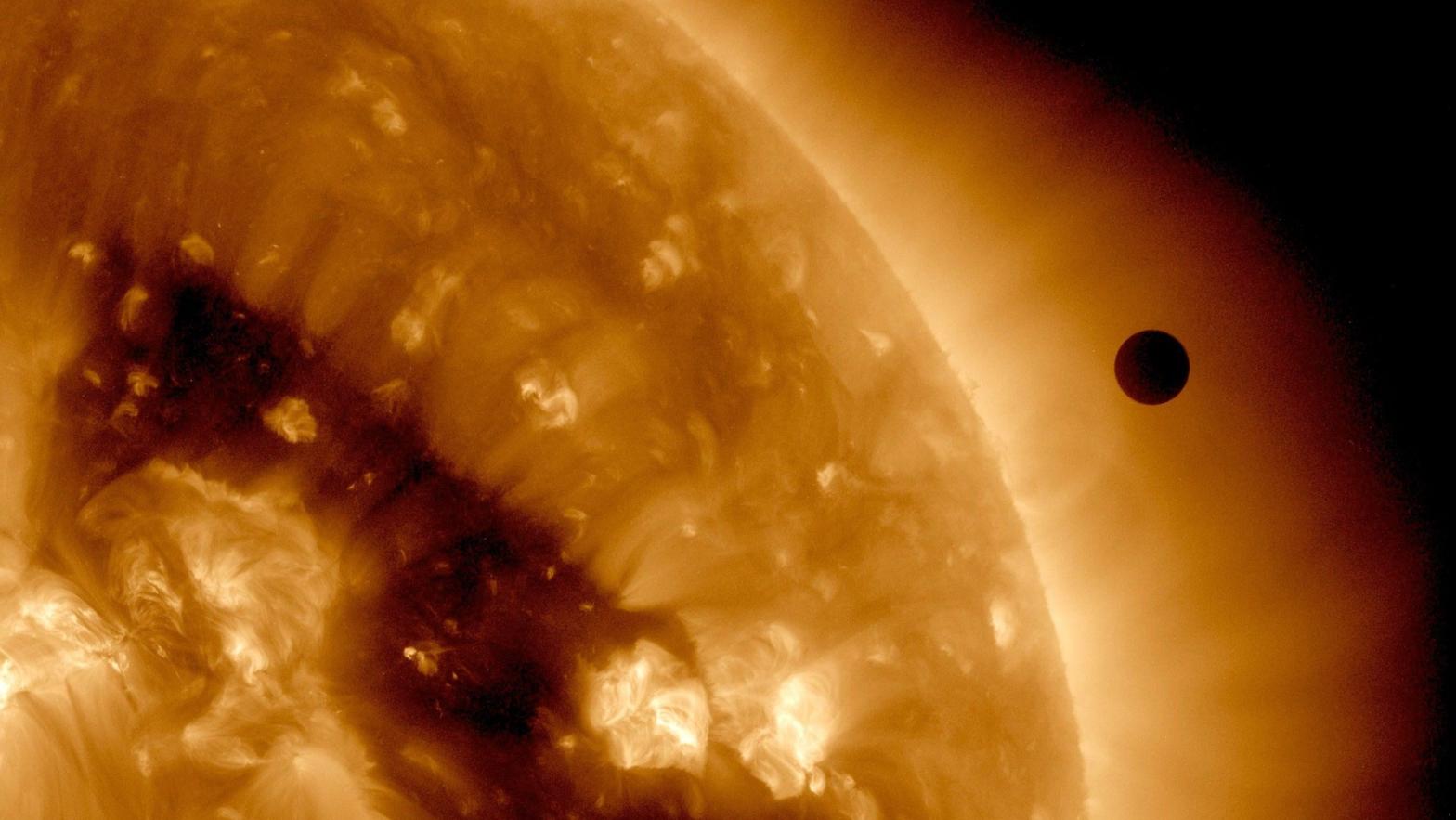 The transit of Venus (right) across the sun's face in 2012, as seen in false colour by the SDO satellite. (Photo: SDO/NASA, Getty Images)