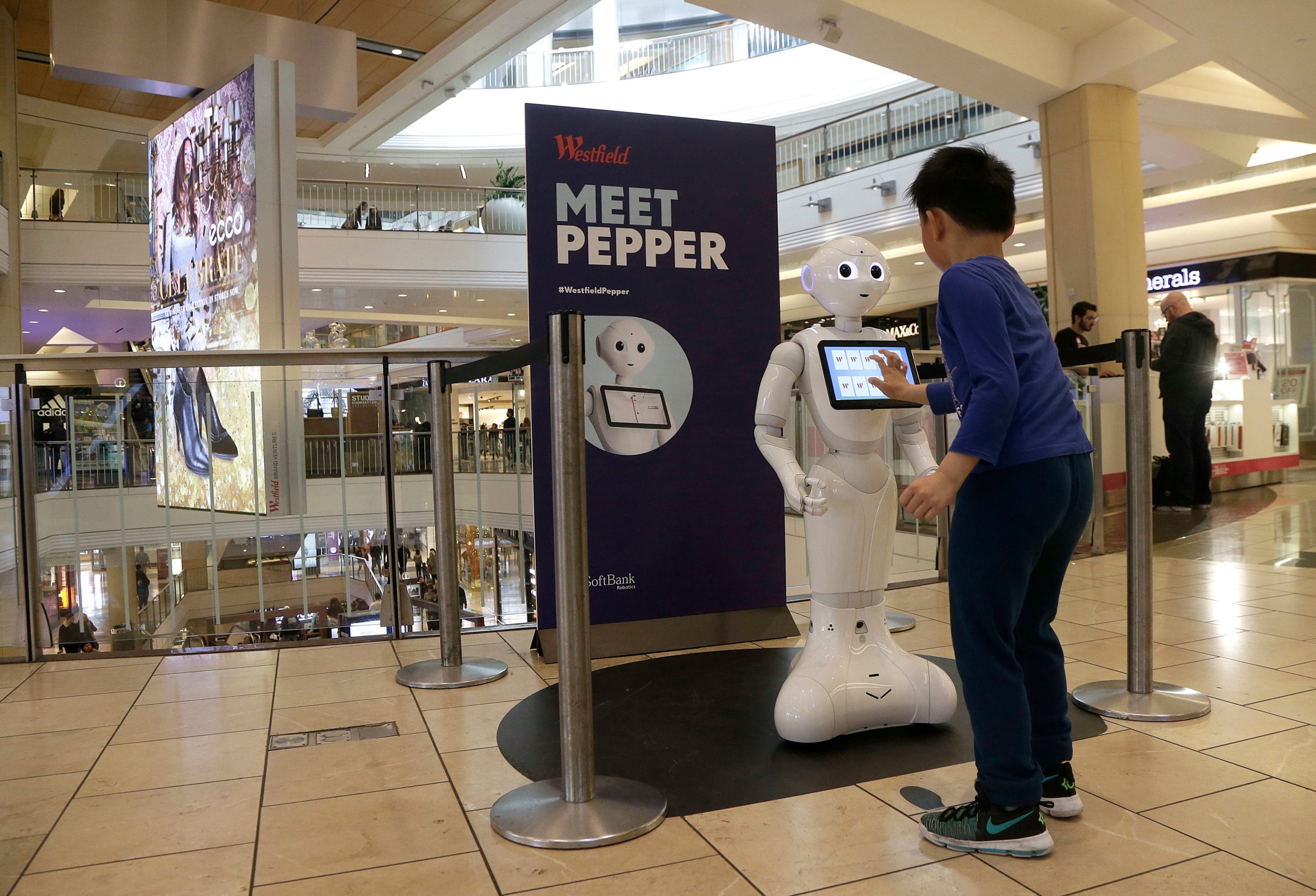 A boy plays with Pepper the robot at Westfield Mall in San Francisco on Dec. 22, 2016.  (Photo: Jeff Chiu, AP)