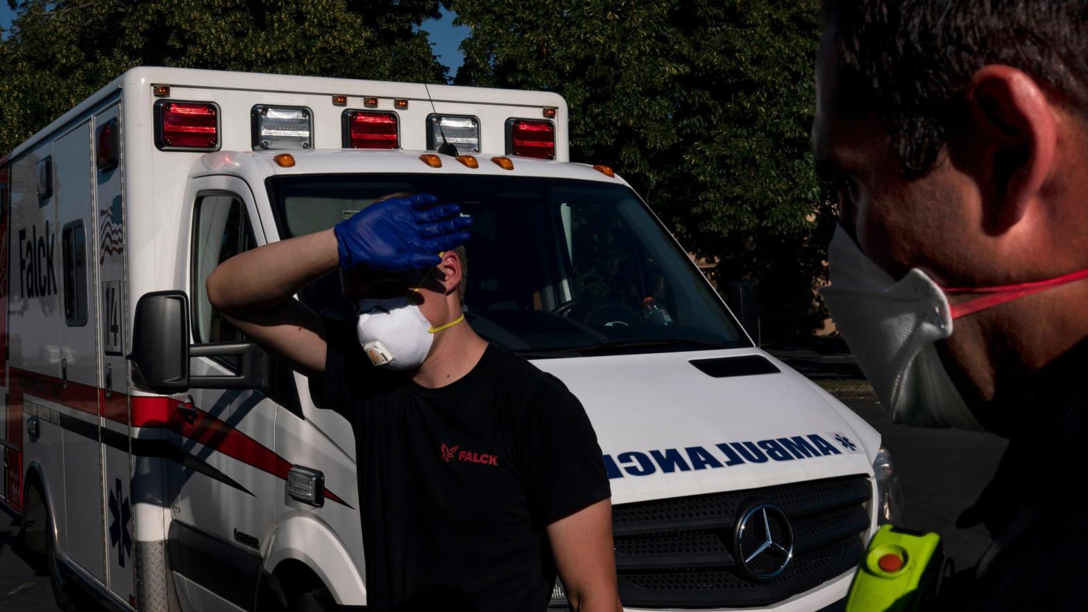 A paramedic shields his eyes while treating a man experiencing heat exposure during a heat wave, Saturday, June 26, 2021, in Salem, Oregon. (Photo: Nathan Howard, AP)