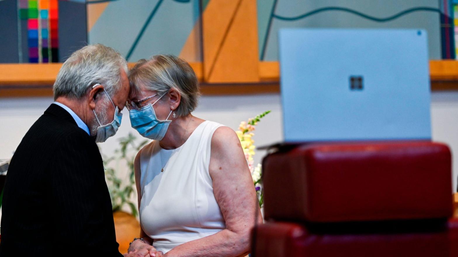 Linda Hoveskeland (R) and Ardell Hoveskeland share a moment with family and friends joining over Zoom after their socially distanced wedding at the Peace Lutheran Church in Alexandria, Virginia on May 28, 2020.  (Photo: Andrew Caballero-Reynolds / AFP, Getty Images)