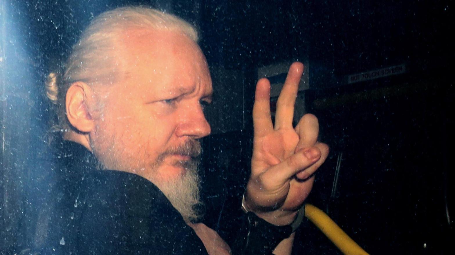 WikiLeaks founder Julian Assange gestures to photographers from a police vehicle while arriving at Westminster Magistrates court in April 2019 in London, England. (Photo: Jack Taylor, Getty Images)