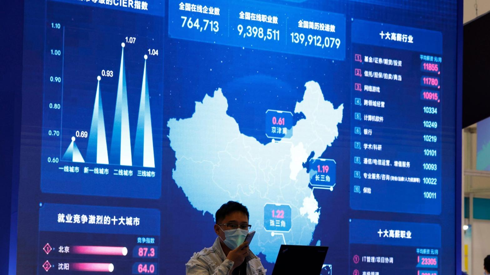 A man stands in front of a large screen showing analytics data about the Chinese web at an internet fair in Beijing in April 2021; used here as stock photo. (Photo: Ng Han Guan, AP)