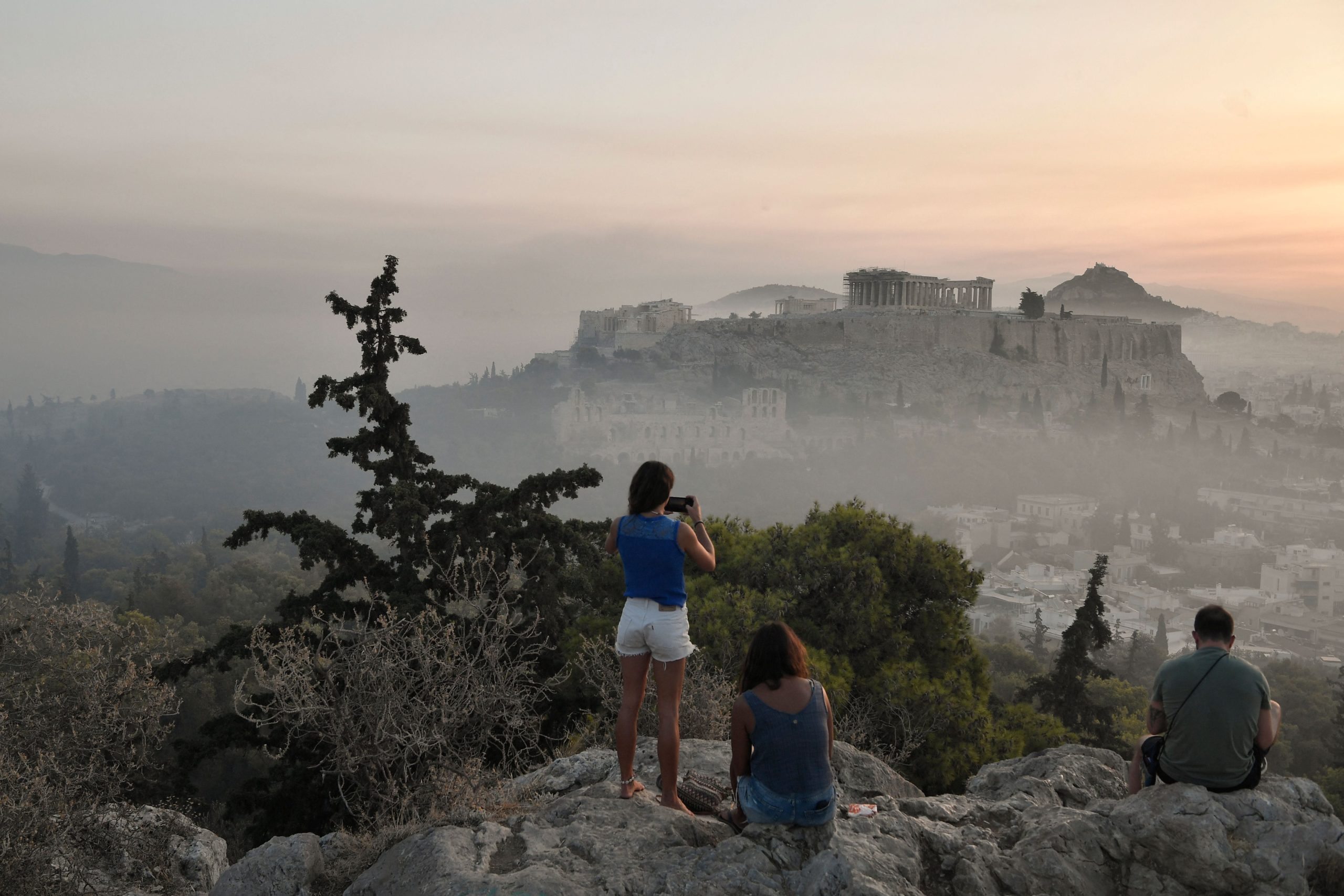 Onlookers take pictures of smoke covering Athens, with the Acropolis in the background. (Photo: Louisa Gouliamaki / AFP, Getty Images)