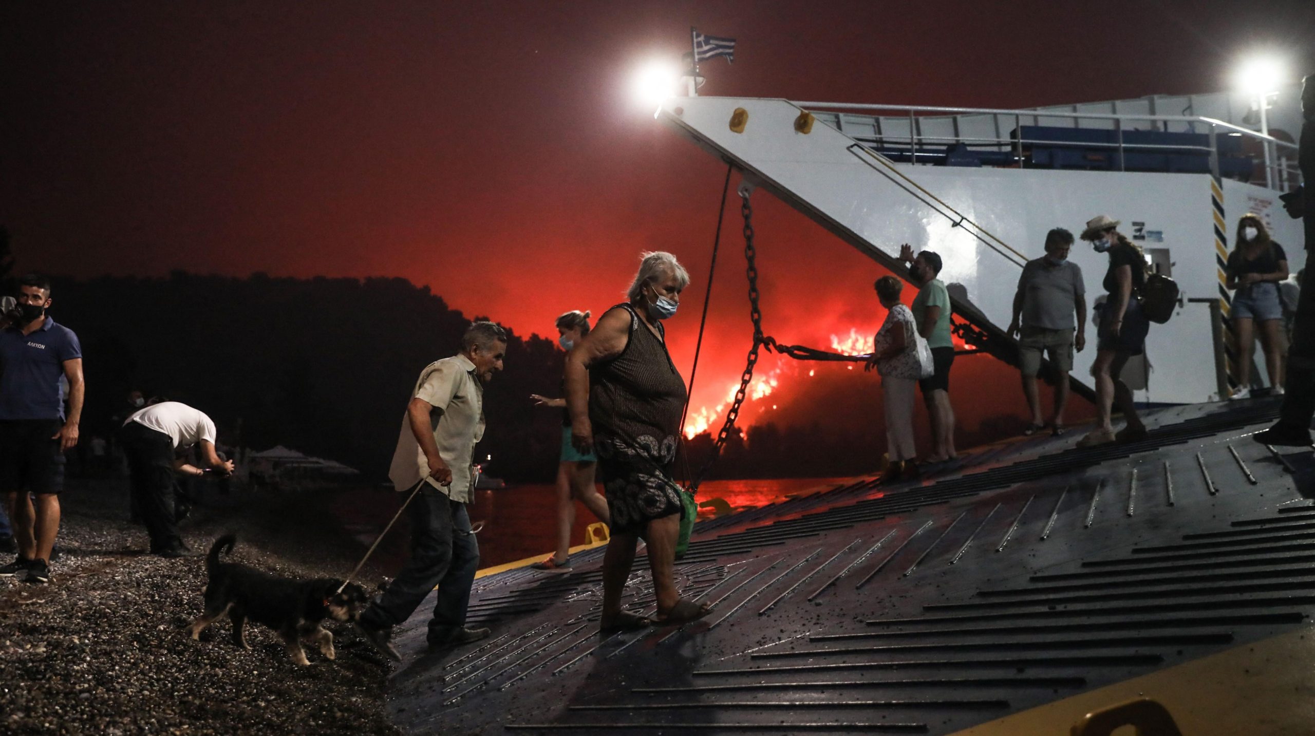 People board a ferry prior to an evacuation as a wildfire approaches the seaside village of Limni on the island of Evia, Greece, on August 6, 2021. (Photo: Sotiris Dimitropoulos, Getty Images)