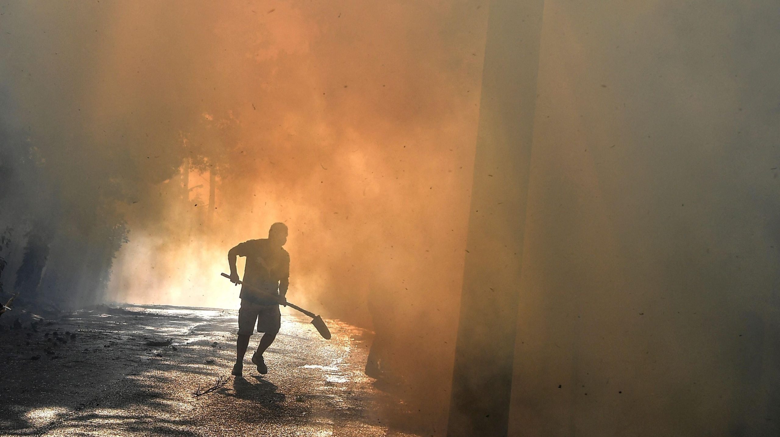 A local resident runs to fight a fire in Thrakomakedones, near Mount Parnitha, north of Athens, Greece, on August 7, 2021.  (Photo: Louisa Gouliamaki, Getty Images)