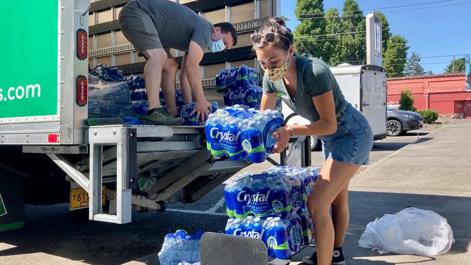 Volunteers and Multnomah County employees unload cases of water to supply a 24-hour cooling centre set up in Portland, Oregon on Wednesday, Aug. 11, 2021. (Photo: Gillian Flaccus, AP)