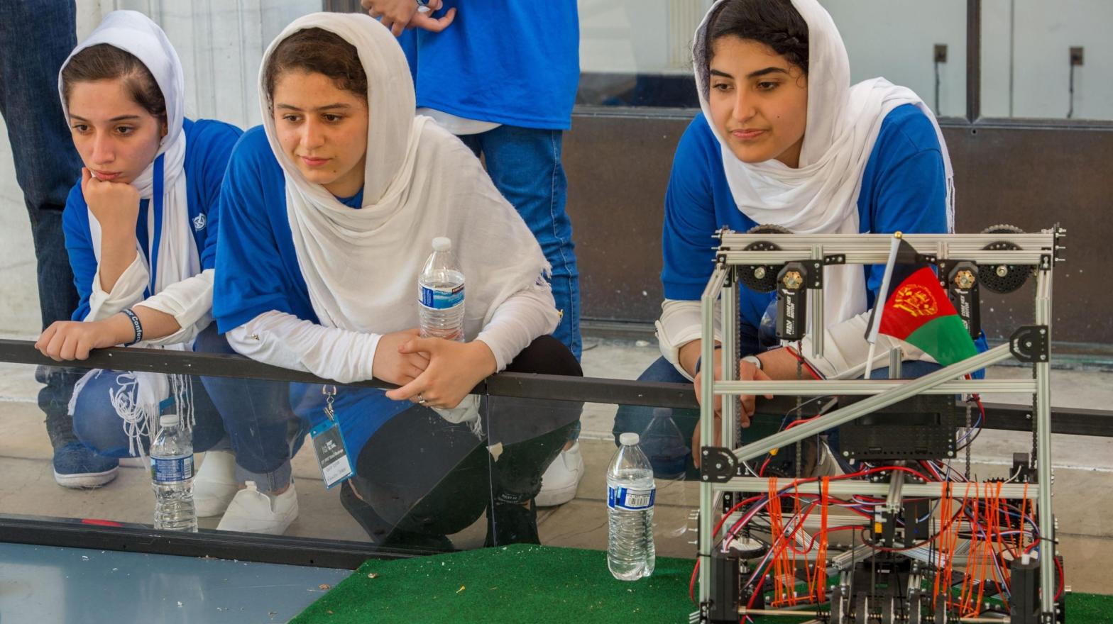 Members of the Afghan all-girls robotics team, with their robot nearby, watch the robots of other countries in the practice area on July 17, 2017 in Washington, D.C.  (Photo: Paul J. Richards/AFP, Getty Images)