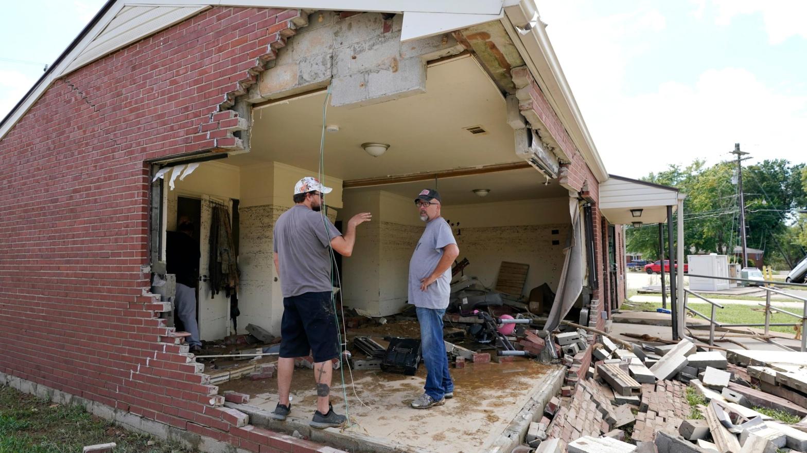 Brian Mitchell, right, looks through the damaged home of his mother-in-law along with family friend Chris Hoover, left, Sunday, Aug. 22, 2021, in Waverly, Tenn.  (Photo: Mark Humphrey, AP)