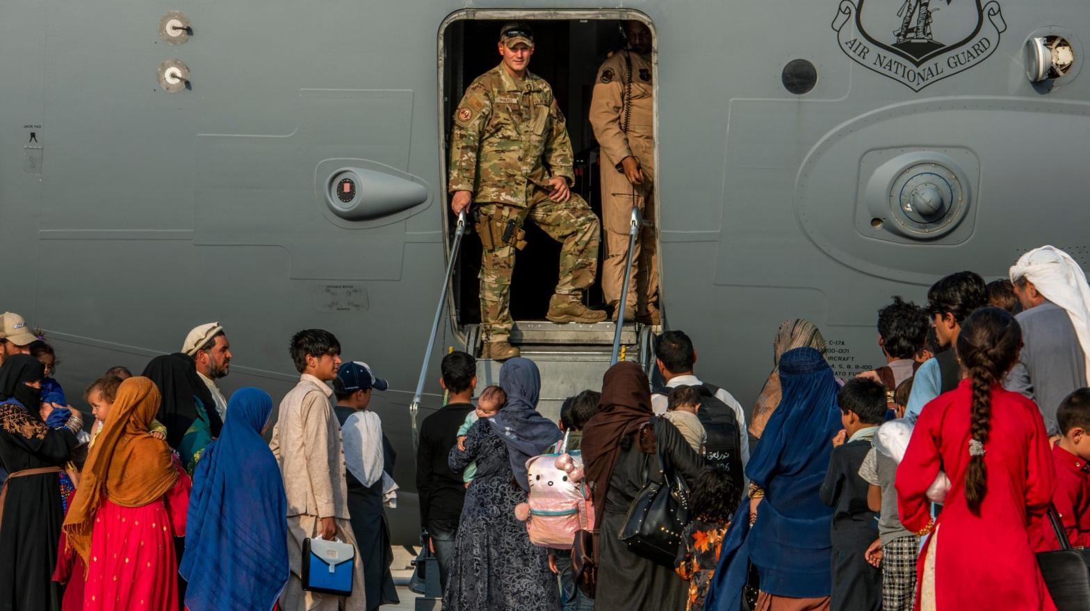 Service members prepare to board evacuees onto a C-17 Globemaster lll on Aug. 22, 2021, at Al Udeid Air Base, Qatar. (Photo: Airman 1st Class Kylie Barrow/U.S. Air Force, AP)
