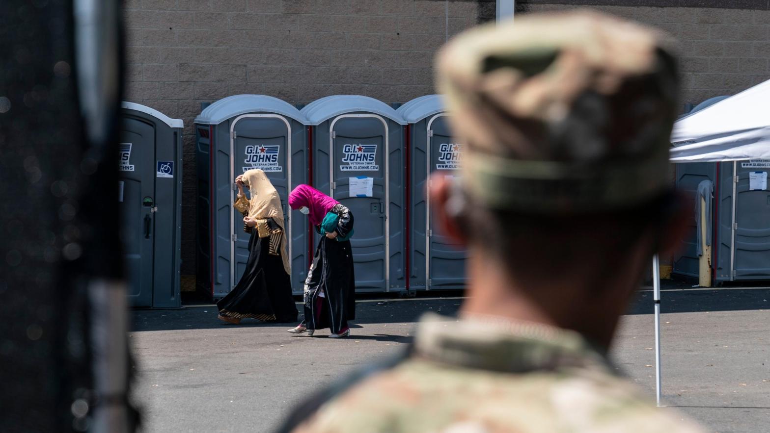 A U.S. soldier watches civilians at a processing centre for Afghan refugees at Dulles Expo Centre in Chantilly, Virginia on Aug. 24, 2021. (Photo: Joshua Roberts, Getty Images)