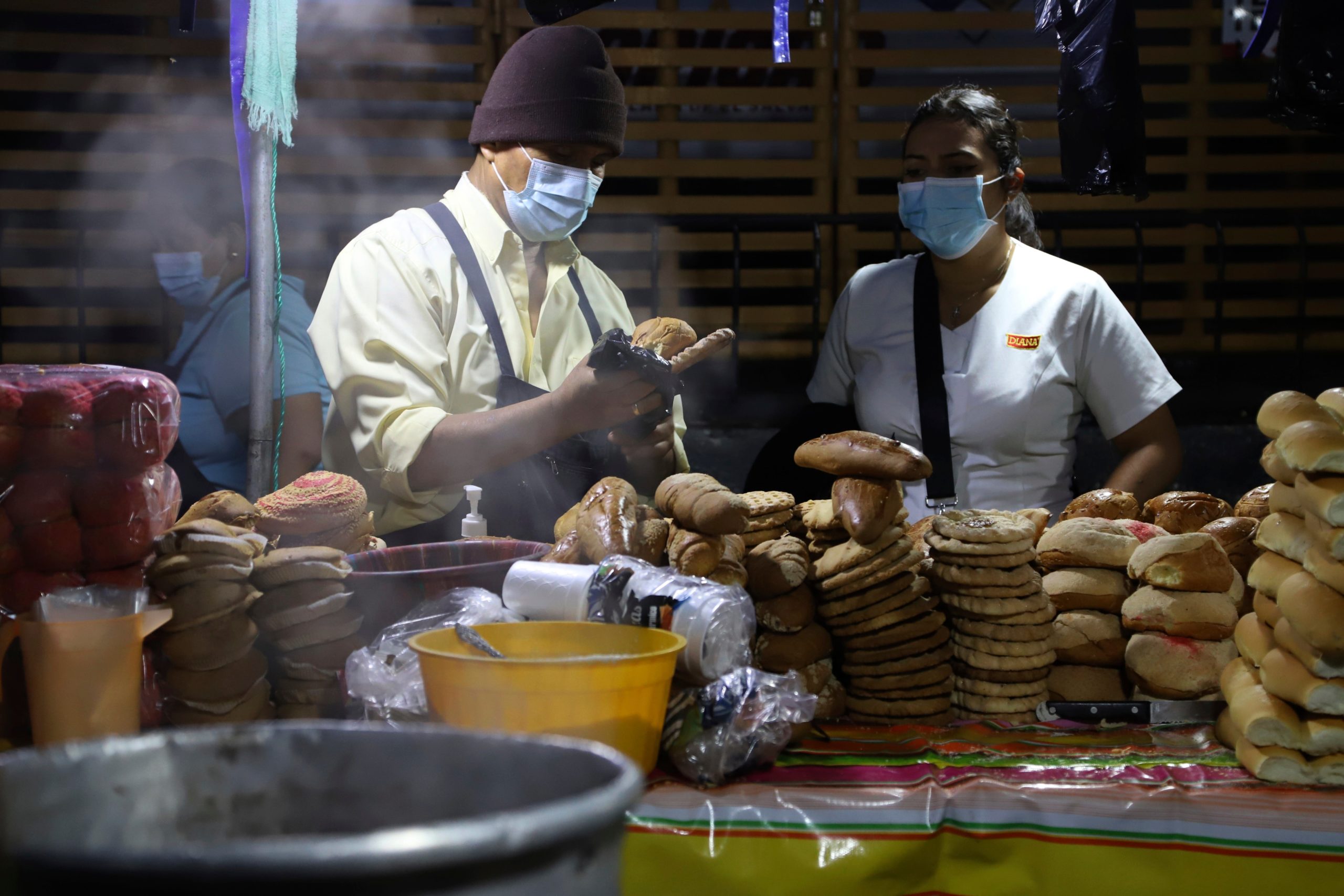 Miguel Menjivar, left, sells bread on a street in San Salvador, El  Salvador, before sunrise Tuesday, Sept. 7, 2021, on the day all  businesses have to accept payments in Bitcoin, except those lacking the  technology to do so. (Photo: Salvador Melendez, AP)