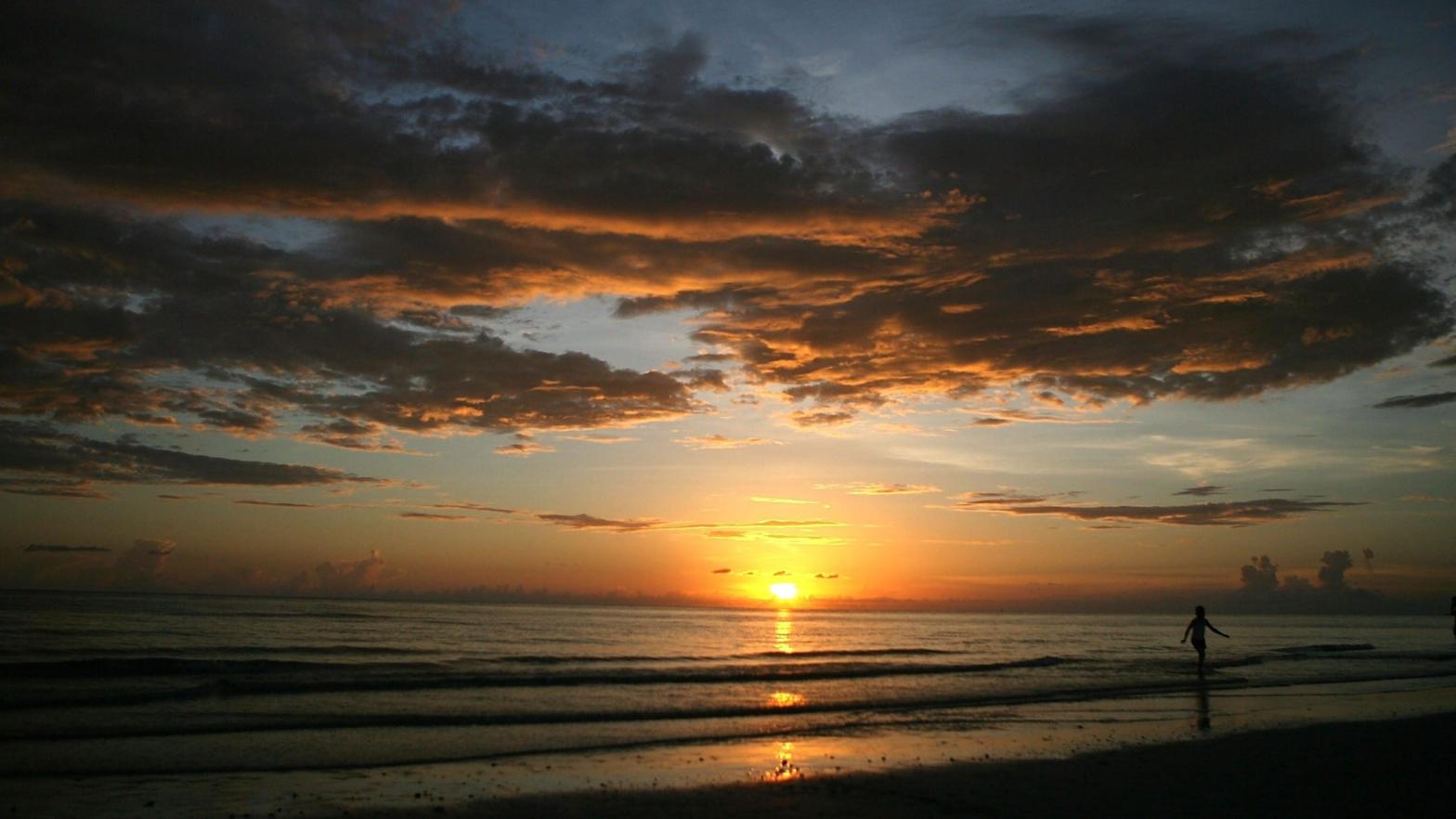 A person walking on the beach during sunset on July 16, 2007 in Marco Island, Florida (Photo: Marc Serota, Getty Images)