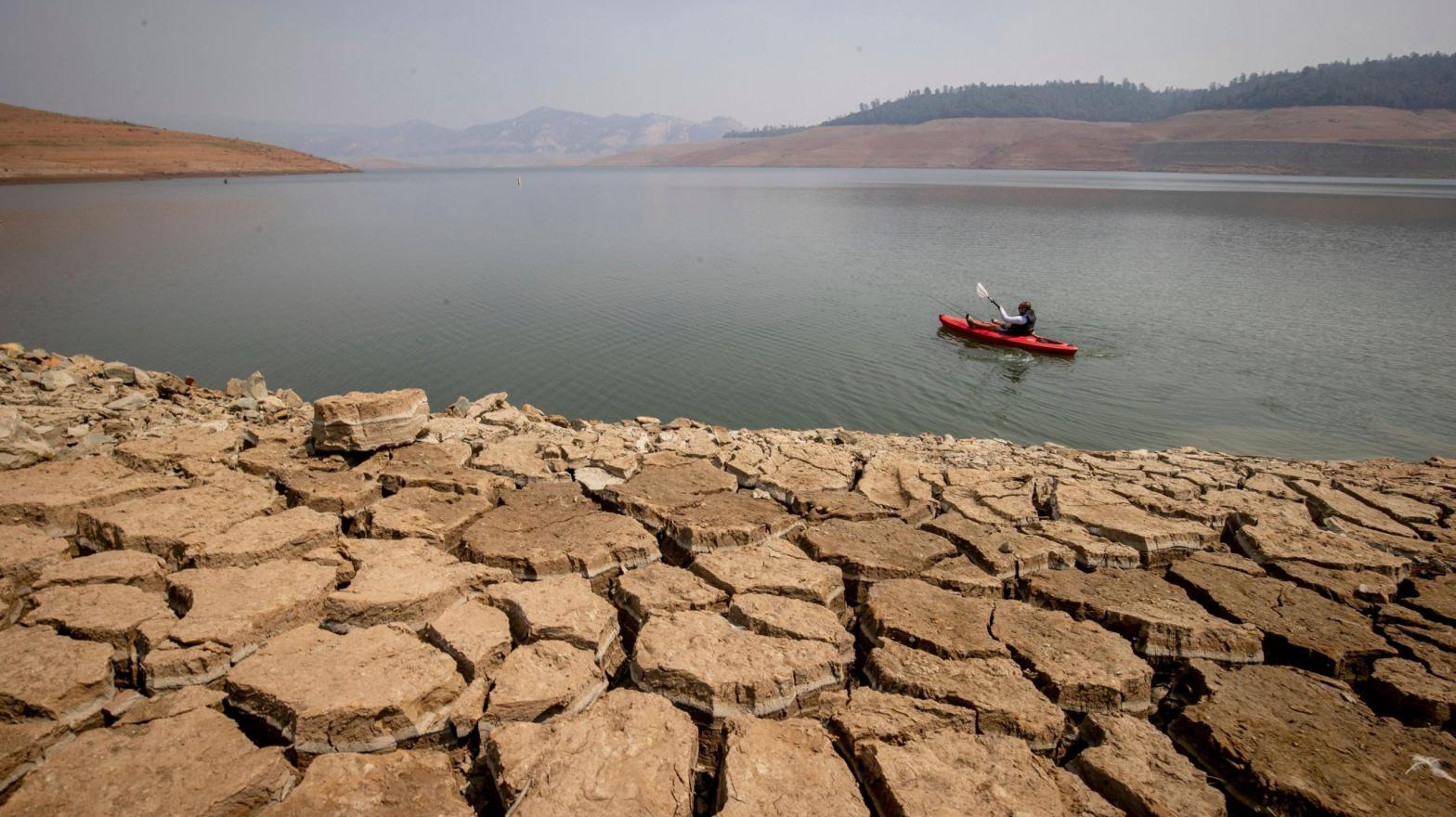 A kayaker fishes in Lake Oroville as water levels remain low due to continuing drought conditions in Oroville, California. (Photo: Ethan Swope, AP)