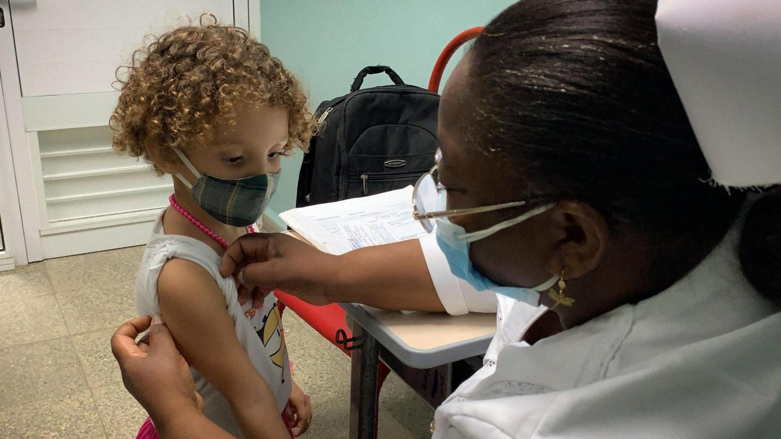 A nurse prepares Roxana Montano, 3, to receive her dose of Soberana Plus, a Cuban vaccine against covid-19, on August 24, 2021 at Juan Manuel Marquez hospital in Havana, as part of the vaccine study in children. (Photo: Adalberto Roque/AFP, Getty Images)