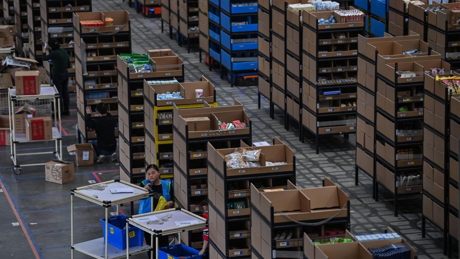 Employees put products in shelves which are then moved by robots in the warehouse of Cainiao Smart Logistics Network, the logistics affiliate of e-commerce giant Alibaba, in Wuxi, China's eastern Jiangsu province. (Photo: Hector Retamal/AFP, Getty Images)