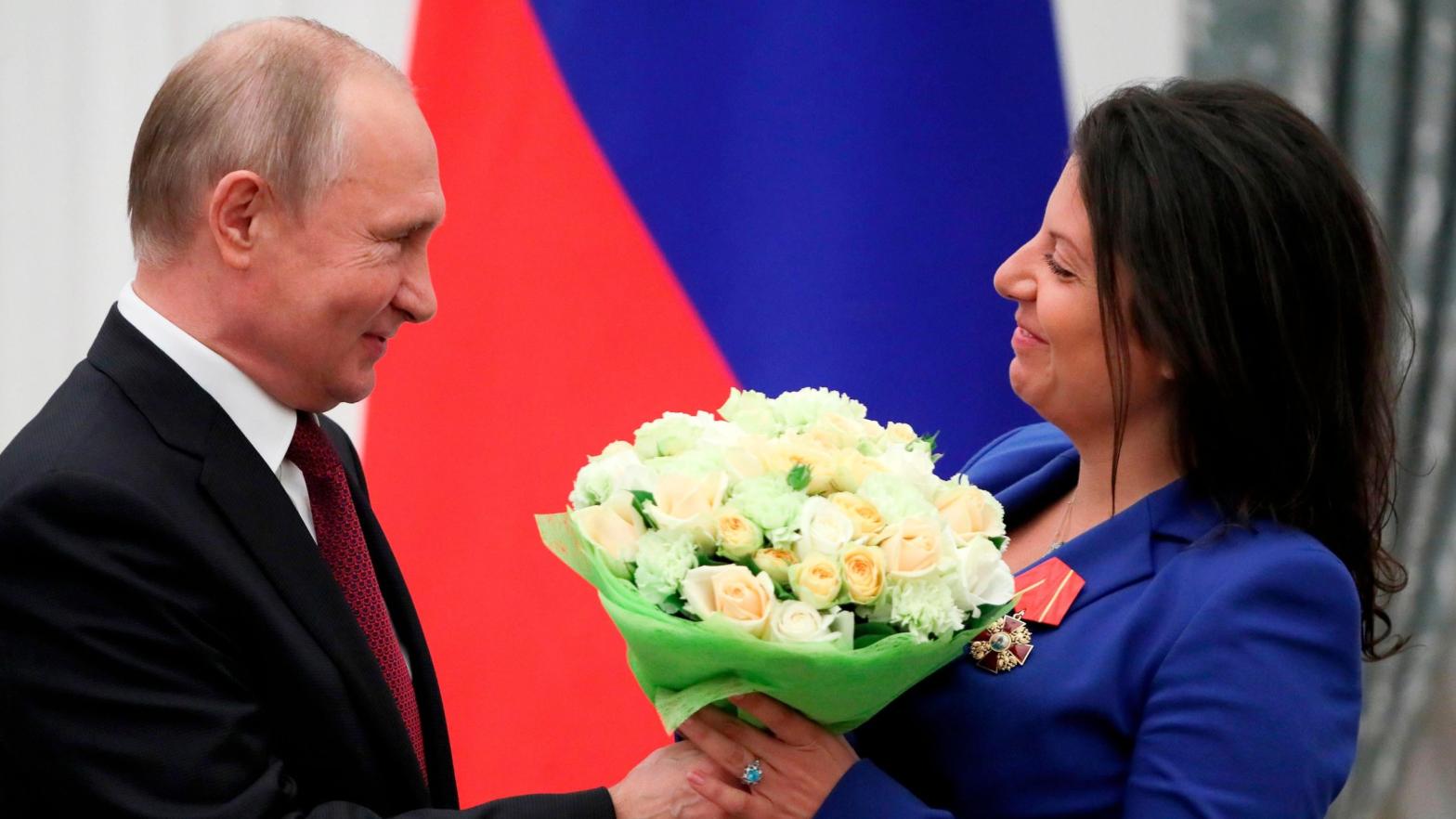 Russian President Vladimir Putin presents flowers to editor-in-chief of Russian state broadcaster RT, Margarita Simonyan, at the Kremlin in Moscow on May 23, 2019. (Photo: Evgenia Novozhenina/AFP, Getty Images)