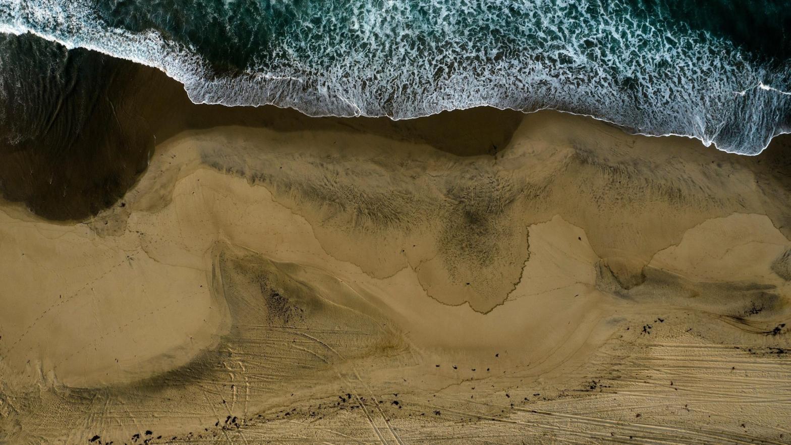 An aerial photo shows the closed beach after oil washed up on Huntington Beach, Calif., on Monday, Oct. 4, 2021. (Photo: Ringo H.W. Chiu, AP)