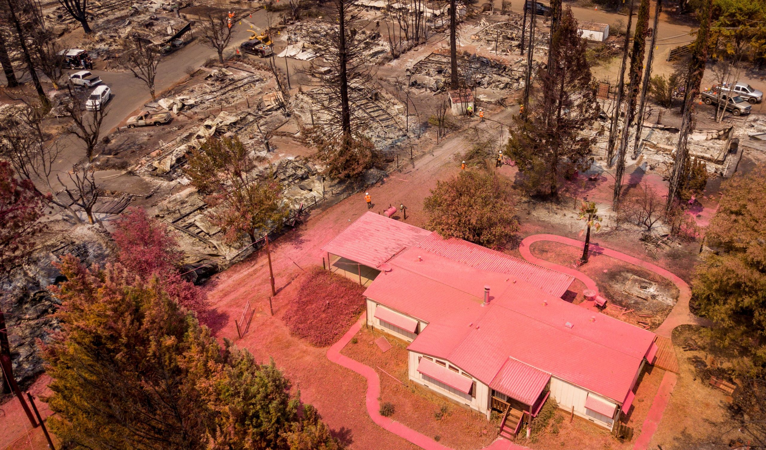 An aerial view shows a home covered in fire retardant near dozens of properties destroyed at the Creekside Mobile Home Park after the Cache fire ripped through the area in Clearlake, California, on Aug. 19, 2021 (Photo: Josh Edelson/AFP, Getty Images)