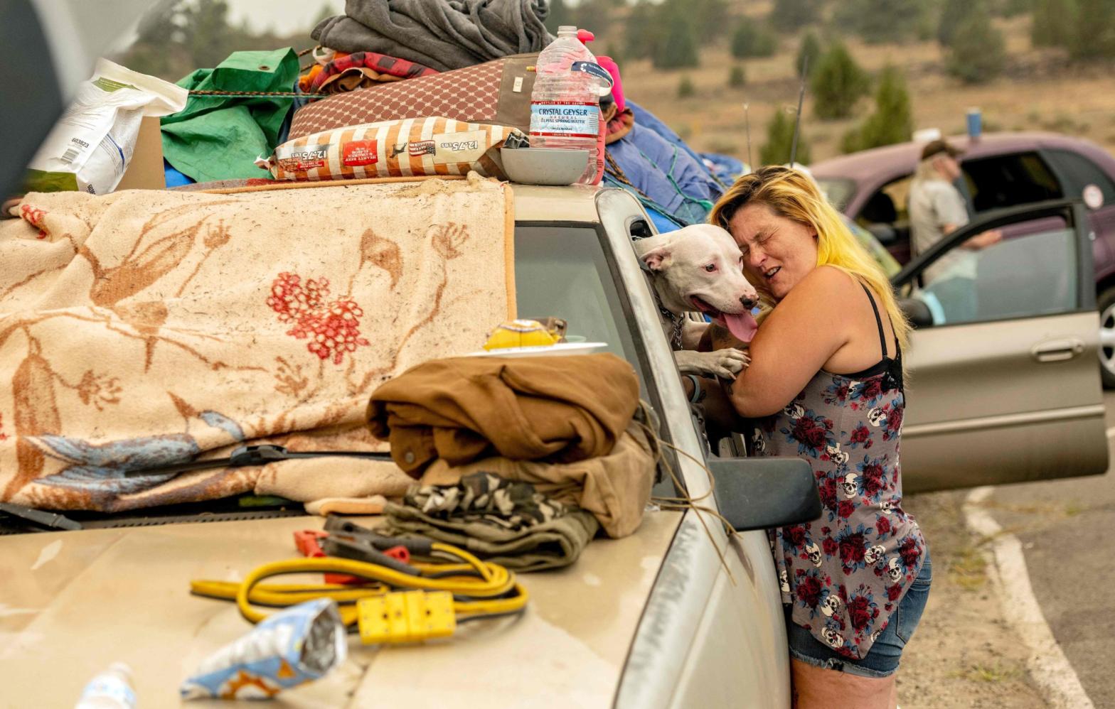 Evacuated Chester resident April Phillips hugs their family dog at an evacuation centre for the Dixie fire in Susanville, California, on Aug. 6, 2021. (Photo: Josh Edelson/AFP, Getty Images)