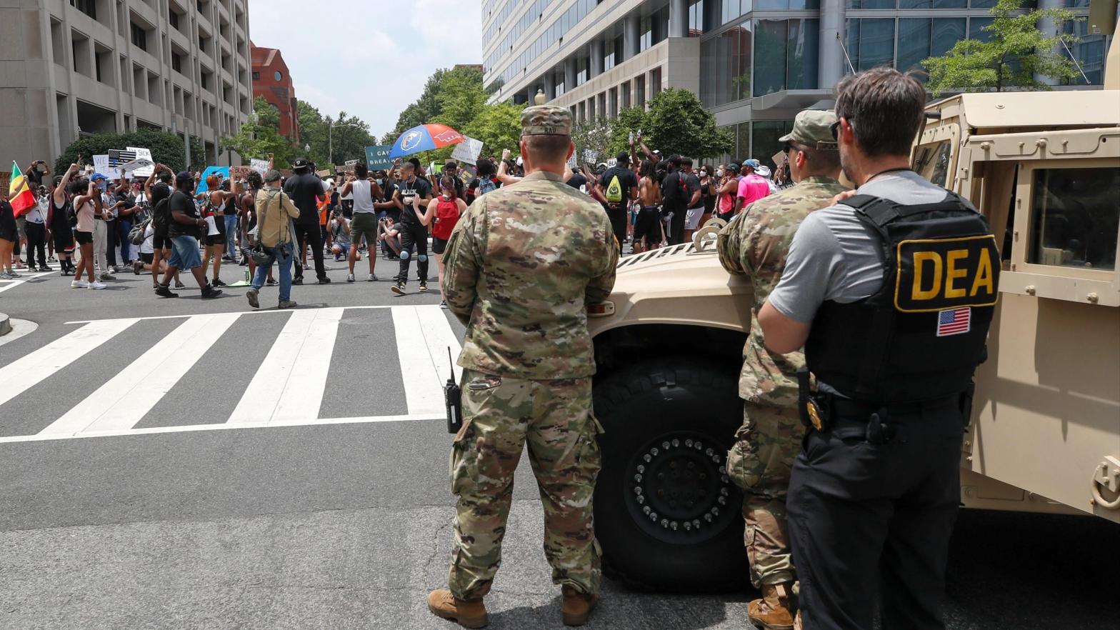 As a Drug Enforcement Agency police office and National Guard soldiers watch, demonstrators protest Saturday, June 6, 2020, in Washington, over the death of George Floyd. (Photo: Alex Brandon, AP)