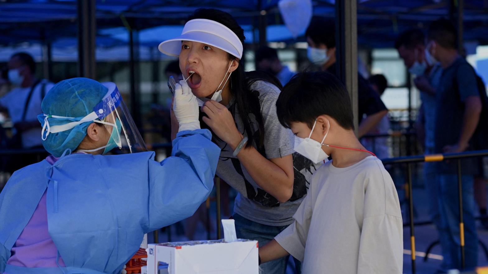 A health worker takes a nucleic acid sample for covid-19 at the arriving passengers terminal at the Zhuhai train station in Zhuhai, in southern China's Guangdong province on September 27, 2021. (Photo: Noel Celis/AFP, Getty Images)