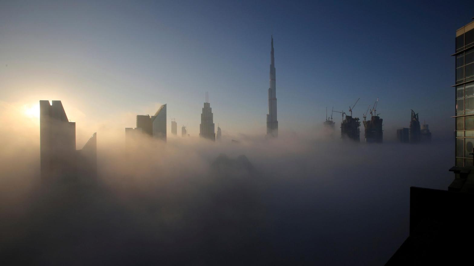 The sun rises over the city skyline with the Burj Khalifa, the world's tallest building at the backdrop, seen from a balcony on the 42nd floor of a hotel on a foggy day in Dubai, United Arab Emirates. (Photo: Kamran Jebreili, AP)